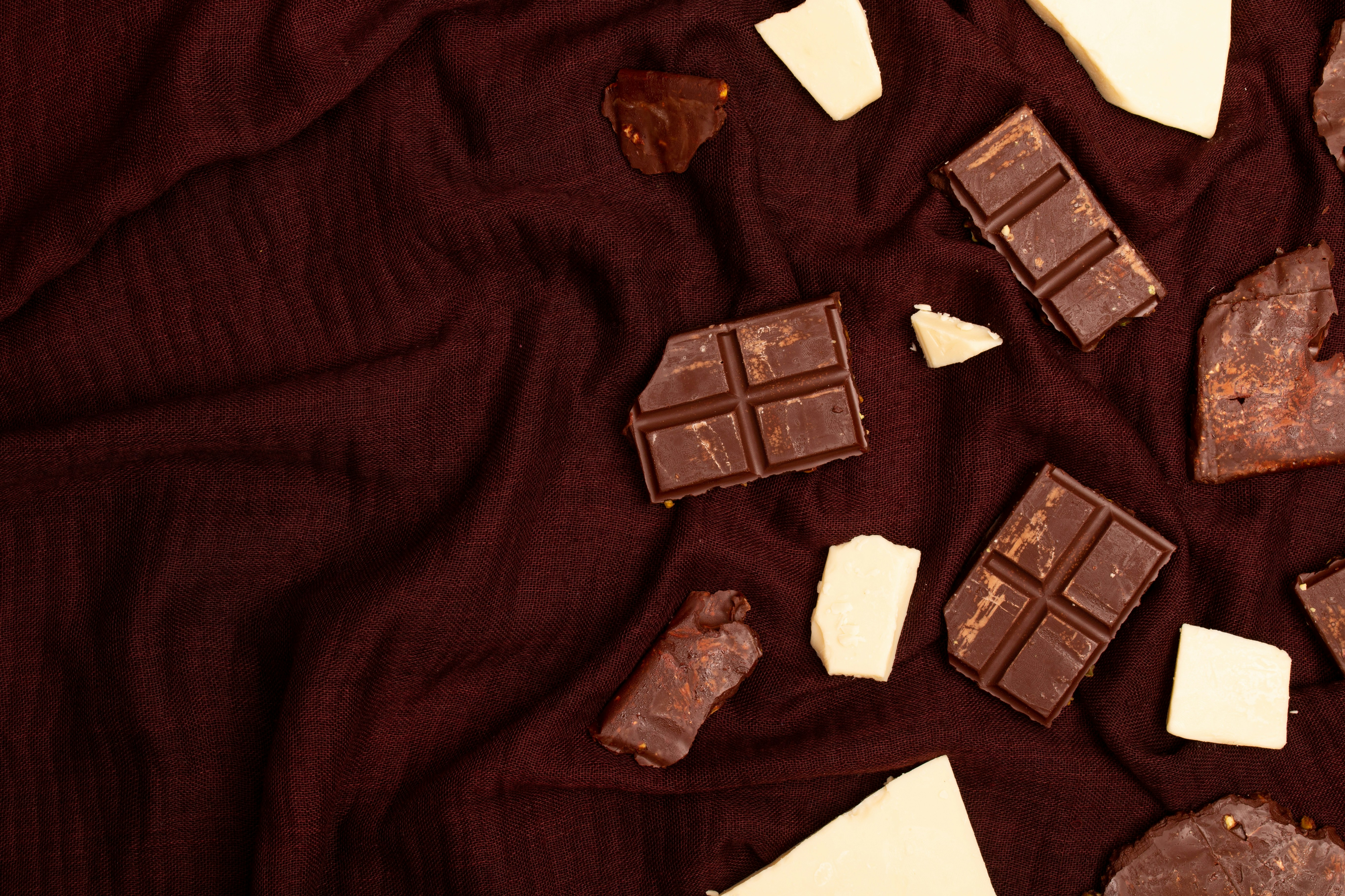 Broken chocolate bars and pieces on dark fabric