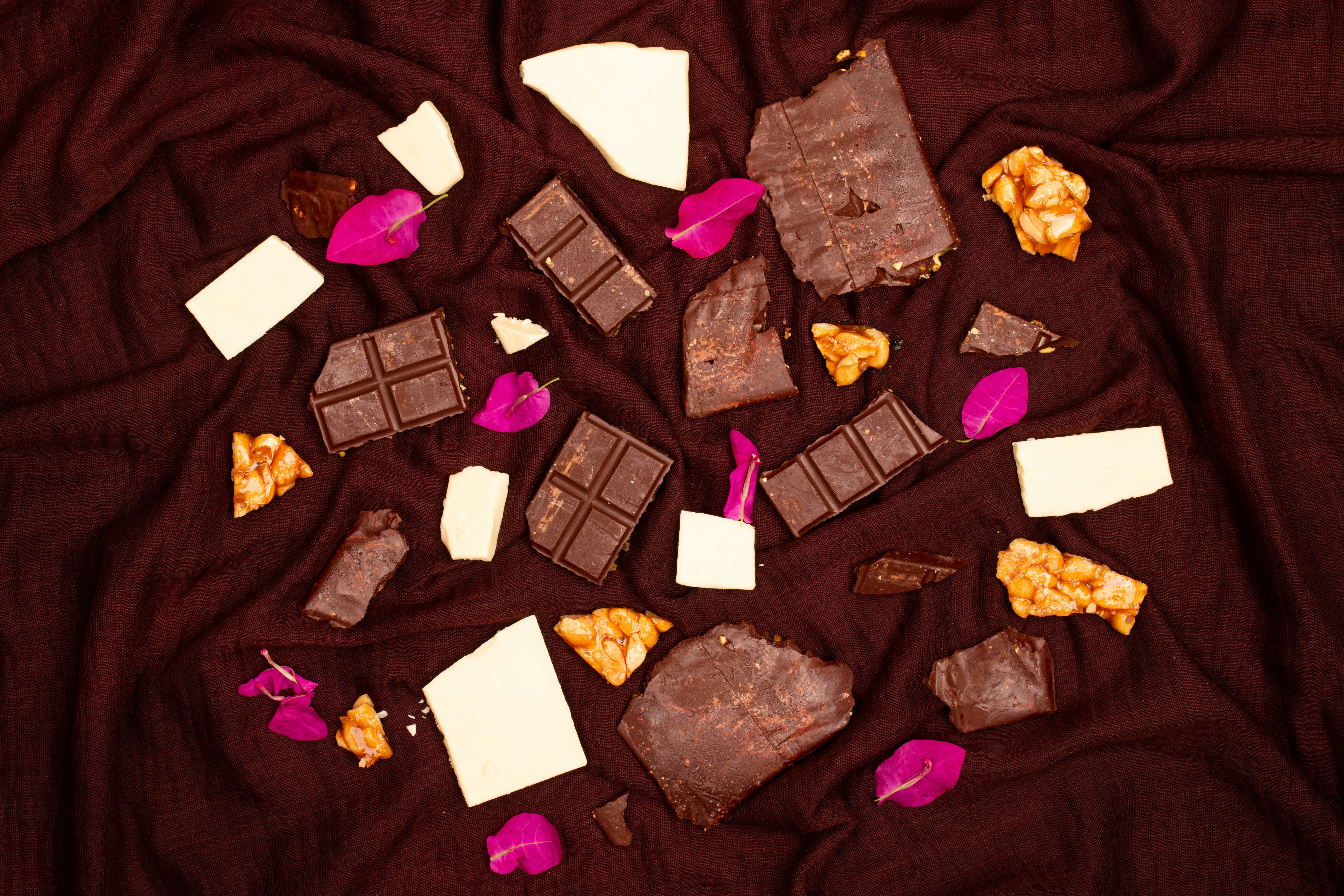 Assorted chocolate pieces scattered on a dark cloth.