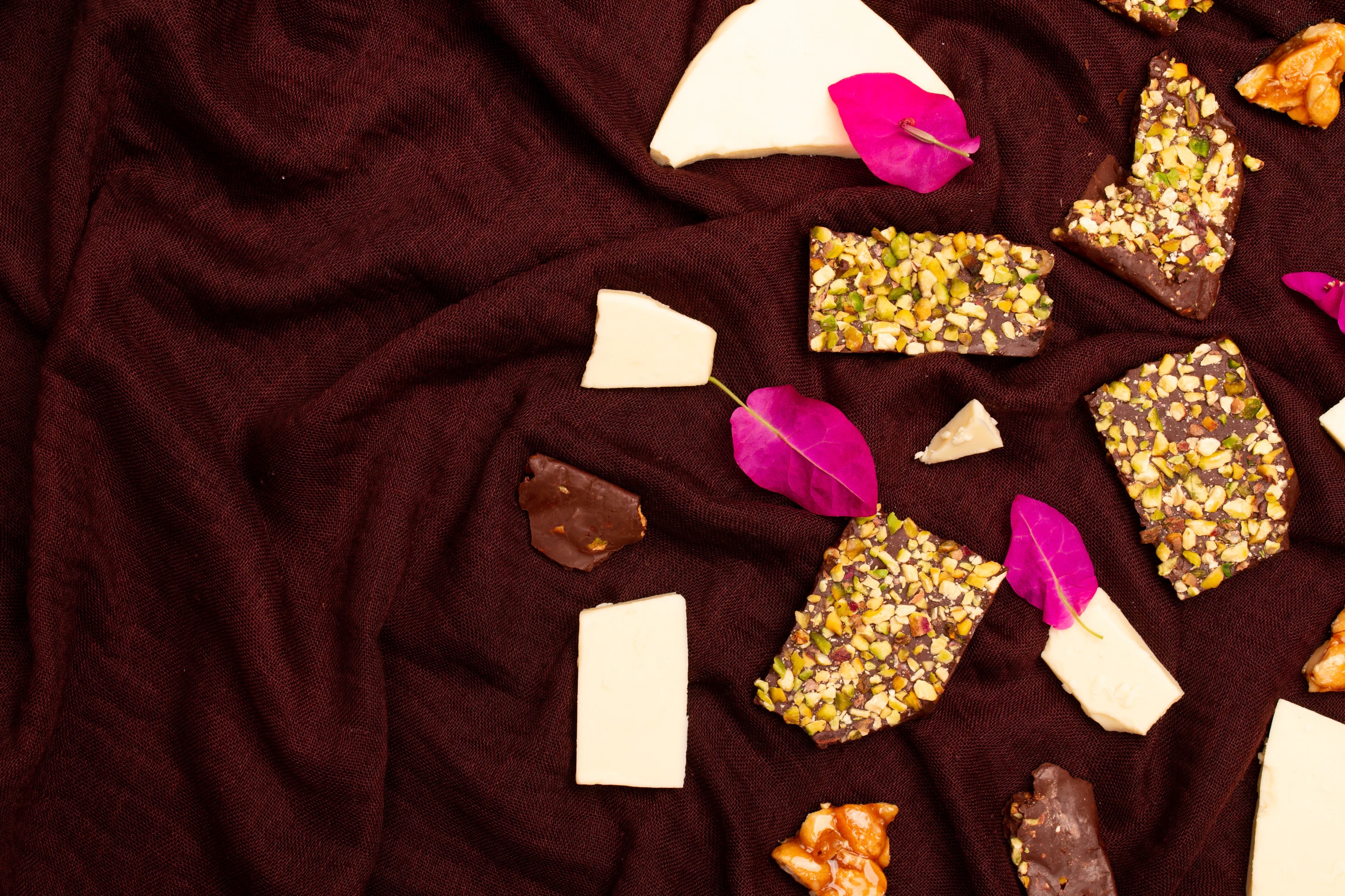 Assortment of chocolates and white chocolate pieces with pistachios.