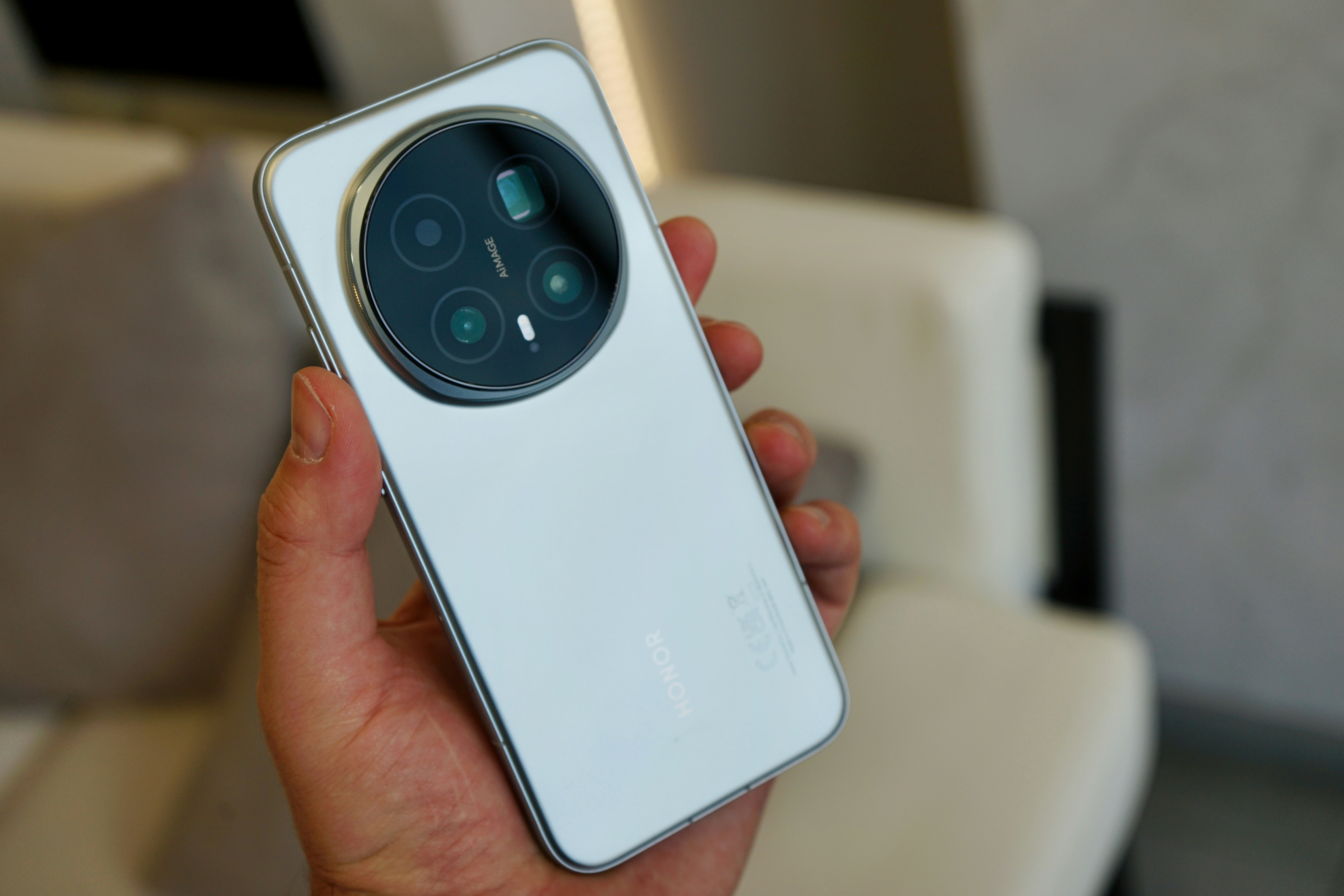 Segurando um smartphone branco com uma matriz de câmeras circular.