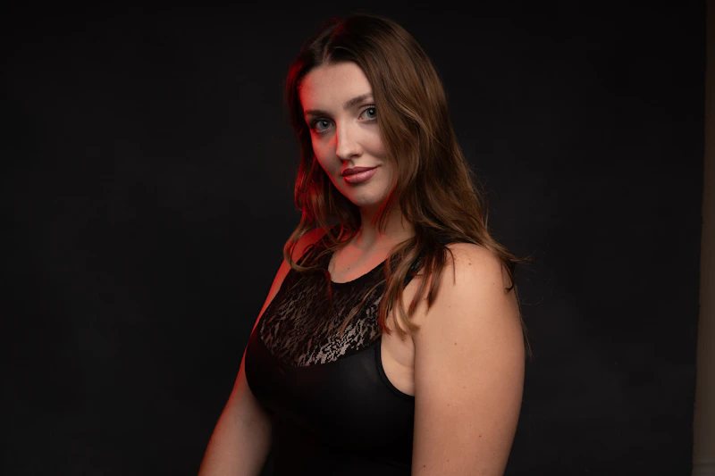 A woman in a black dress with red lighting