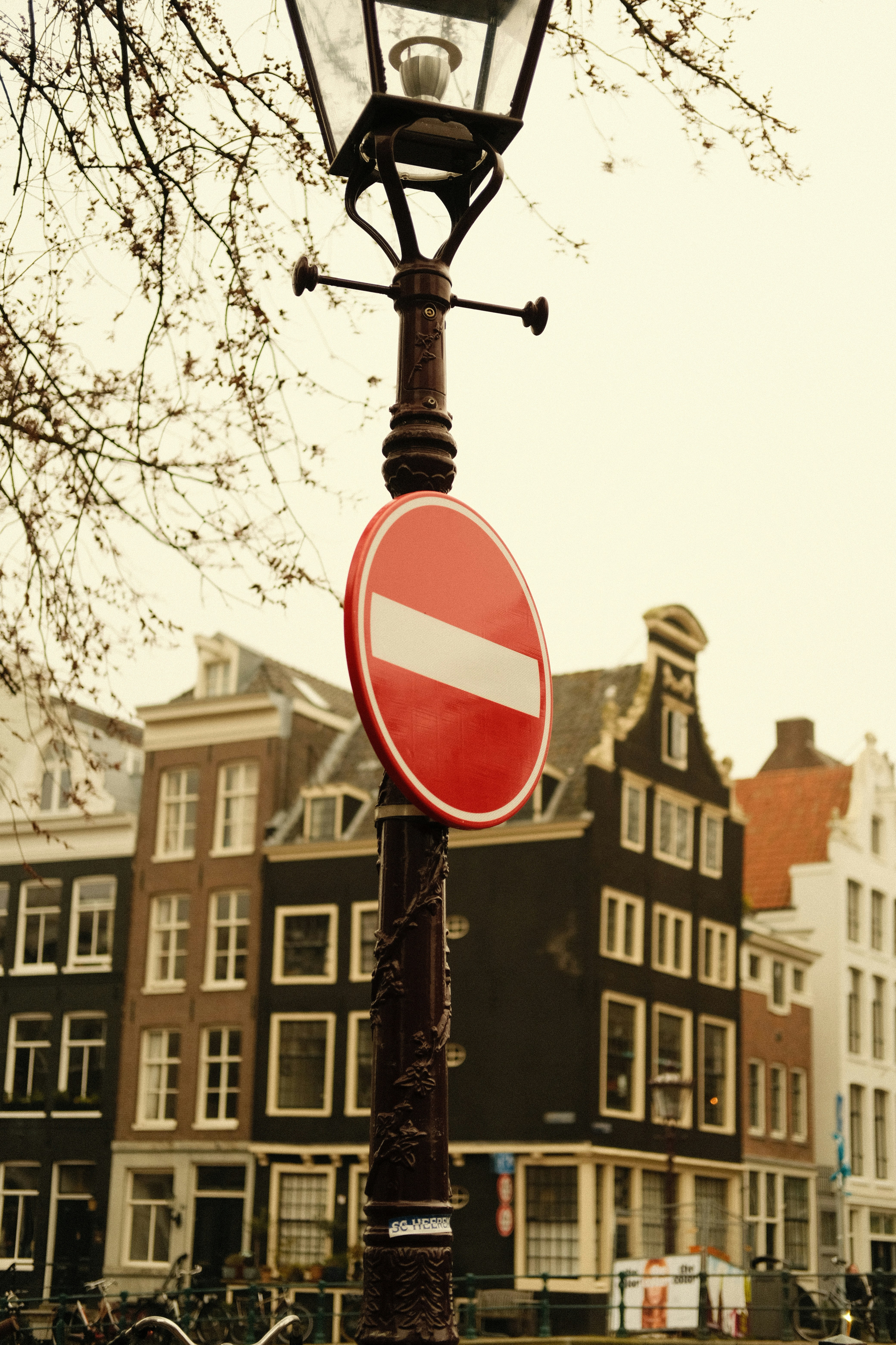 Straßenlaterne mit Eingangsschild vor den Gebäuden