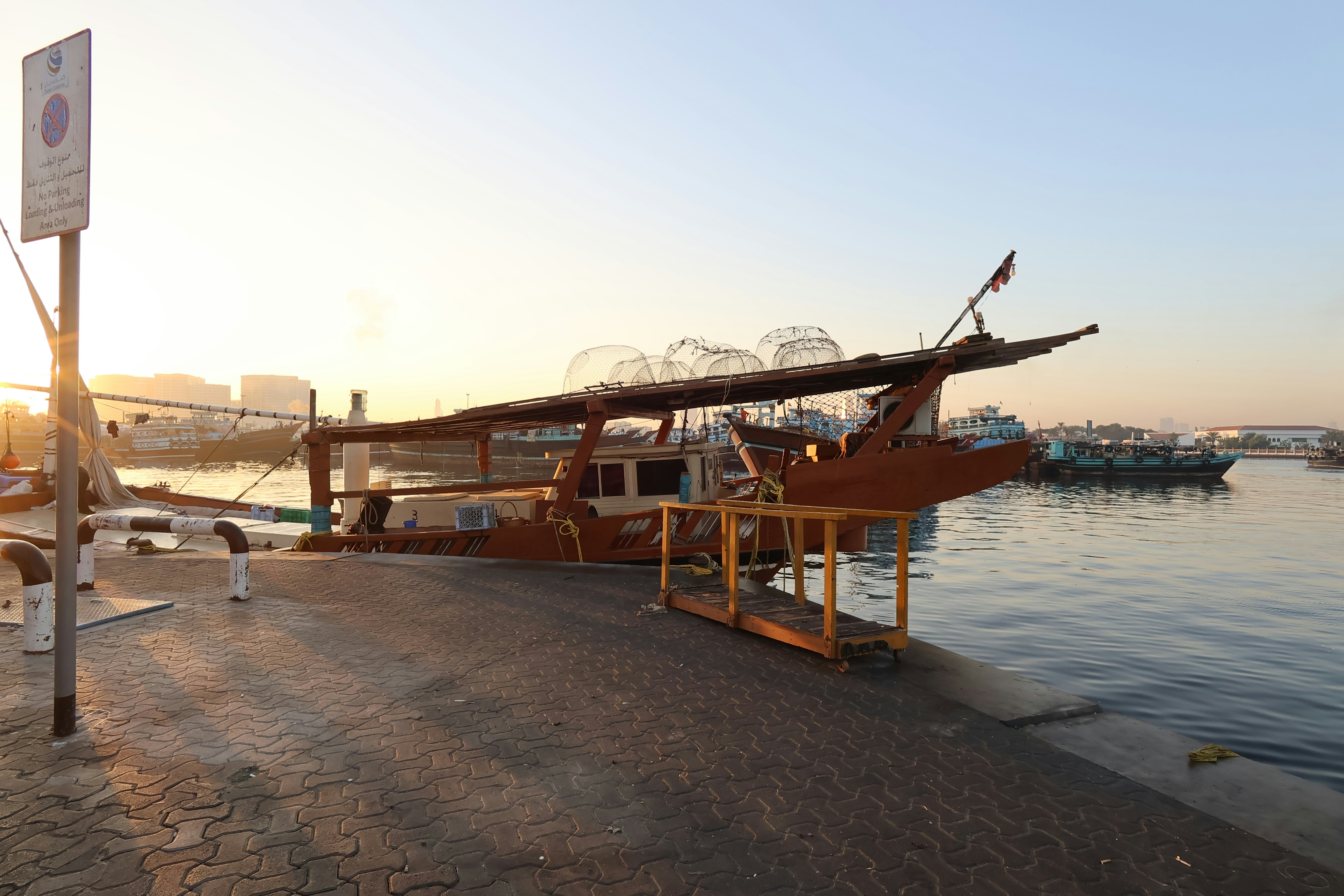 Wooden boat docked by the water at sunset