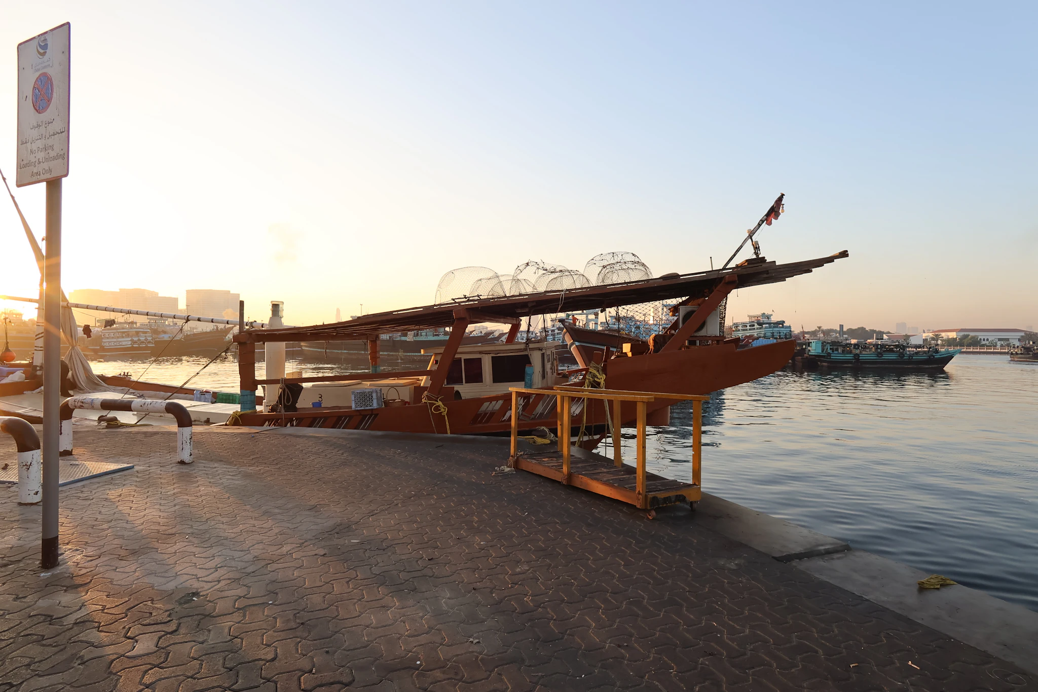 A wooden dhow moored at the Deira wharf at sunset