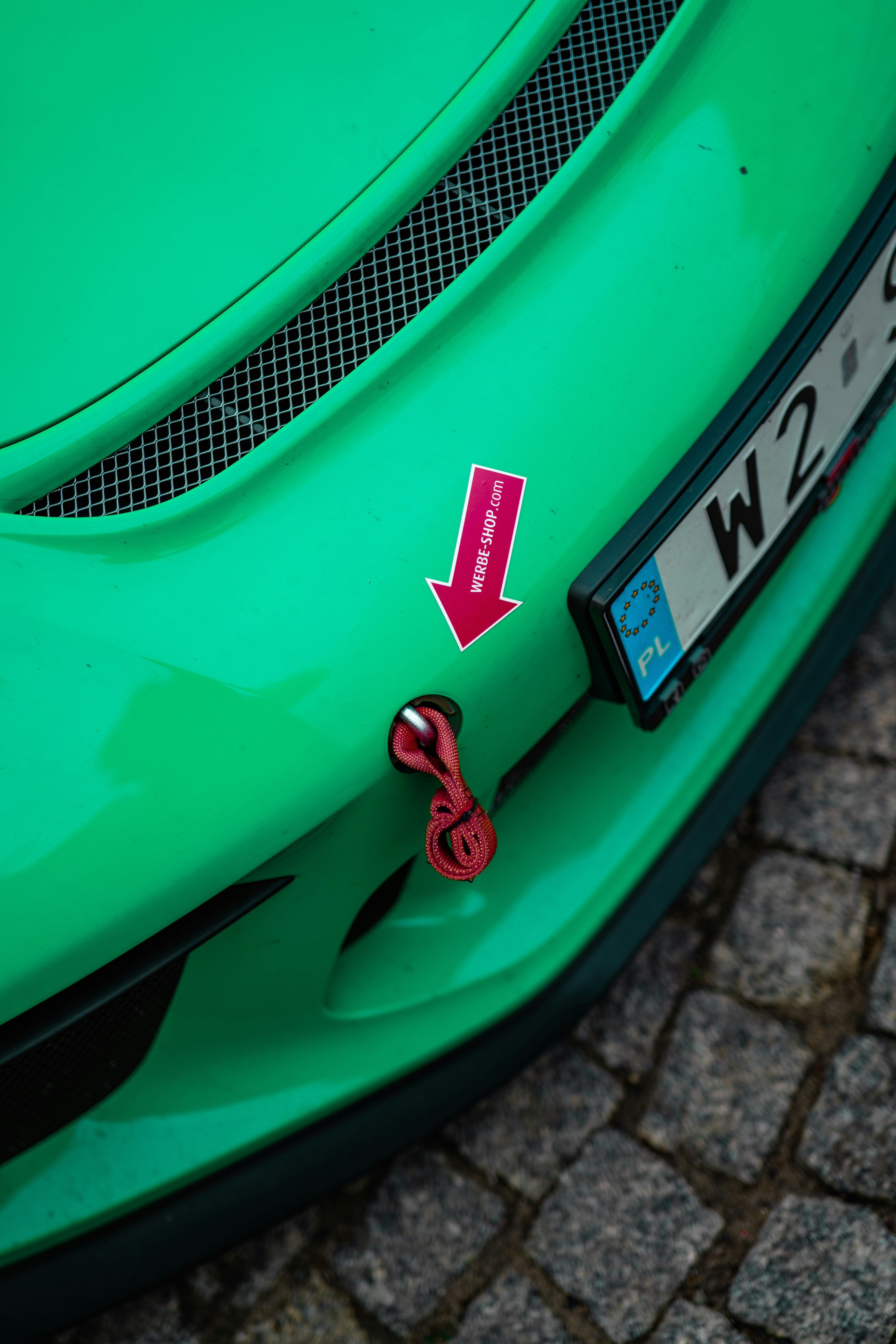 Green race car with red tow hook and sticker.
