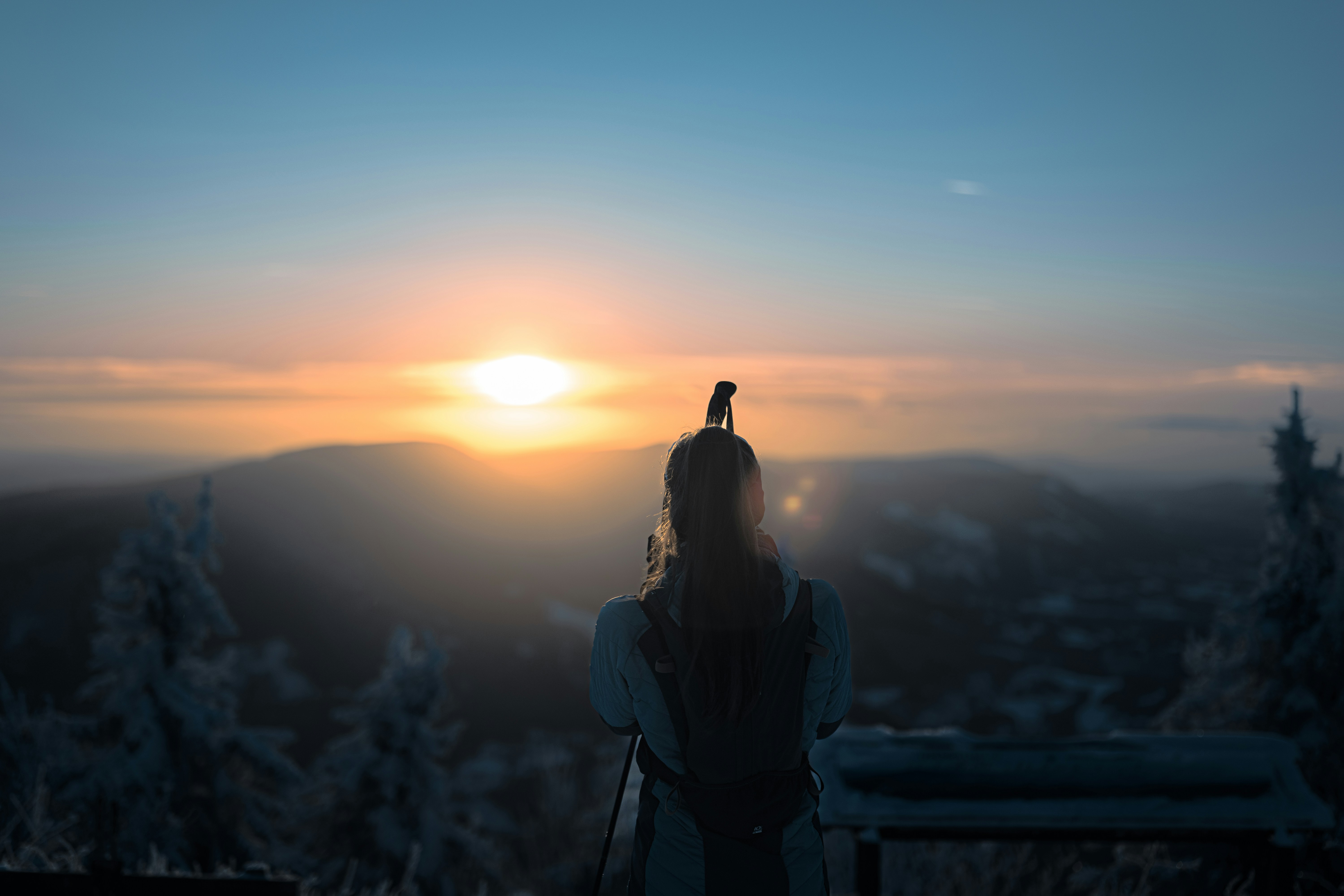 Persona observa el amanecer sobre montañas nevadas