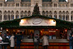 People at a christmas market stall with a tree