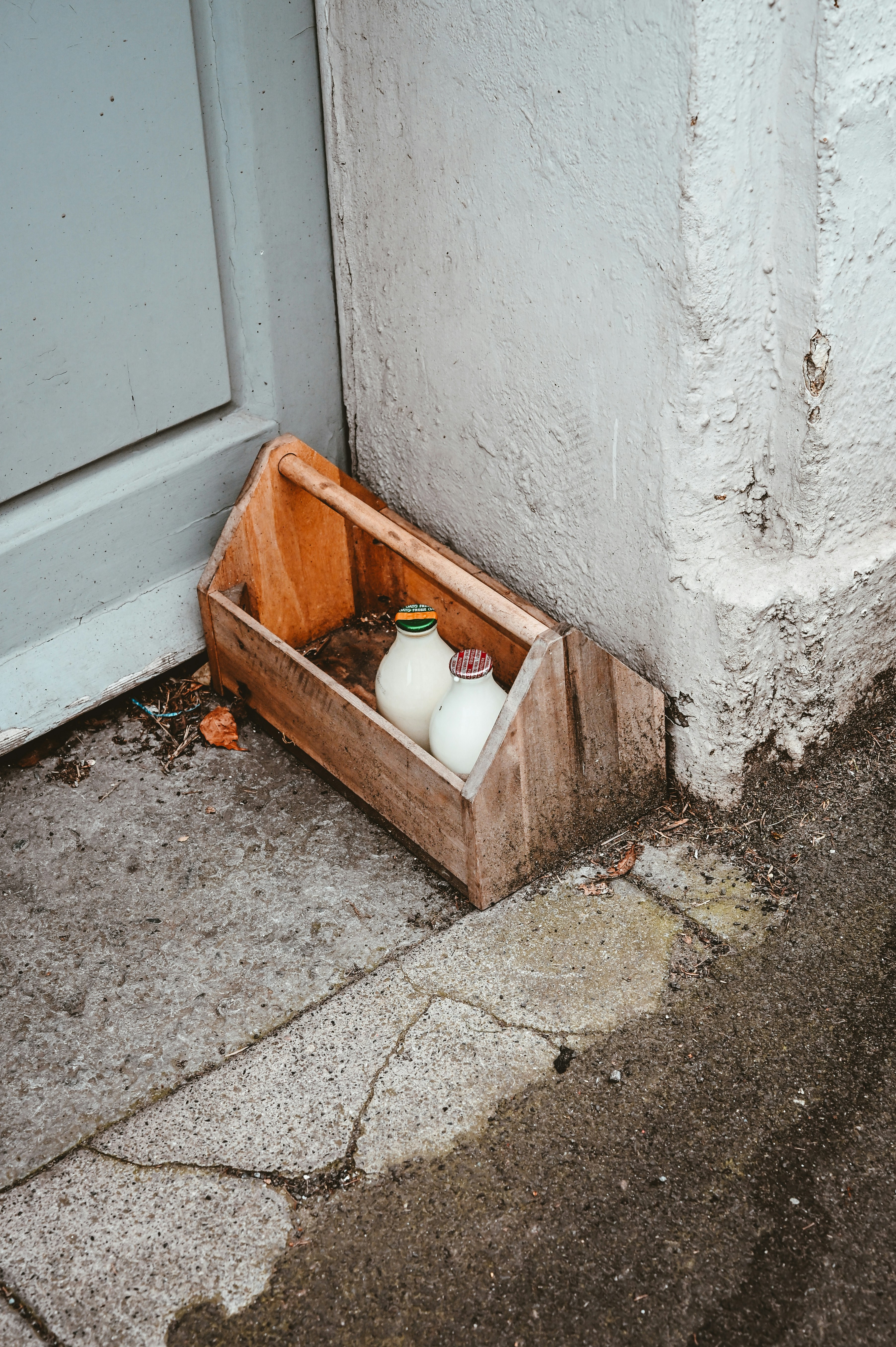 Due bottiglie di latte in vetro in una cassa di legno.