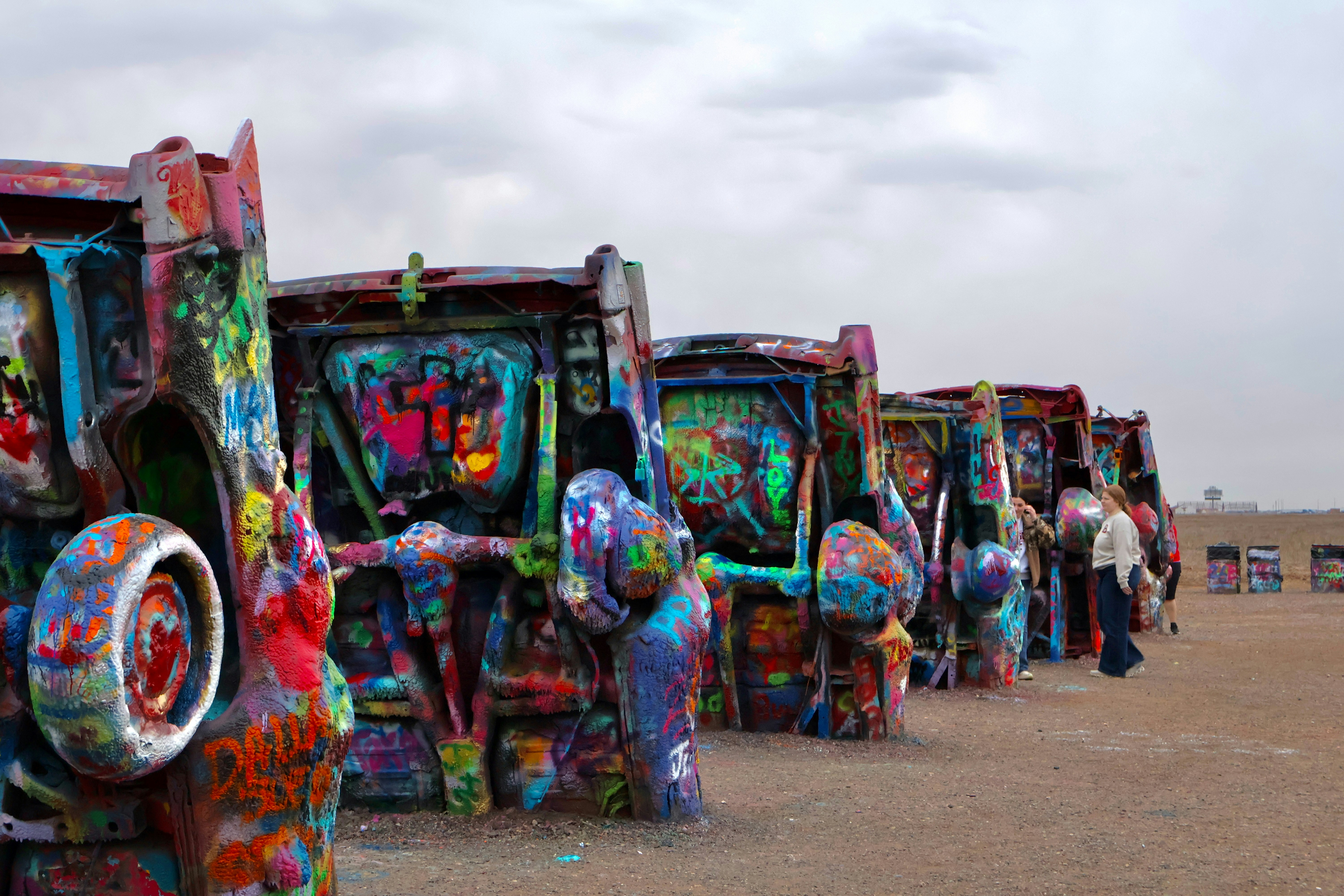 Graffiti-covered cars lined up in a desert landscape
