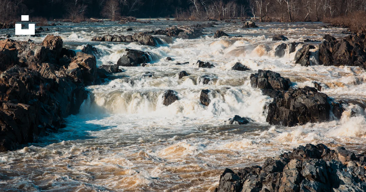 Water Rushing Over Rocks Rushing water cascades over rocks in a wide river. photo – Free ...