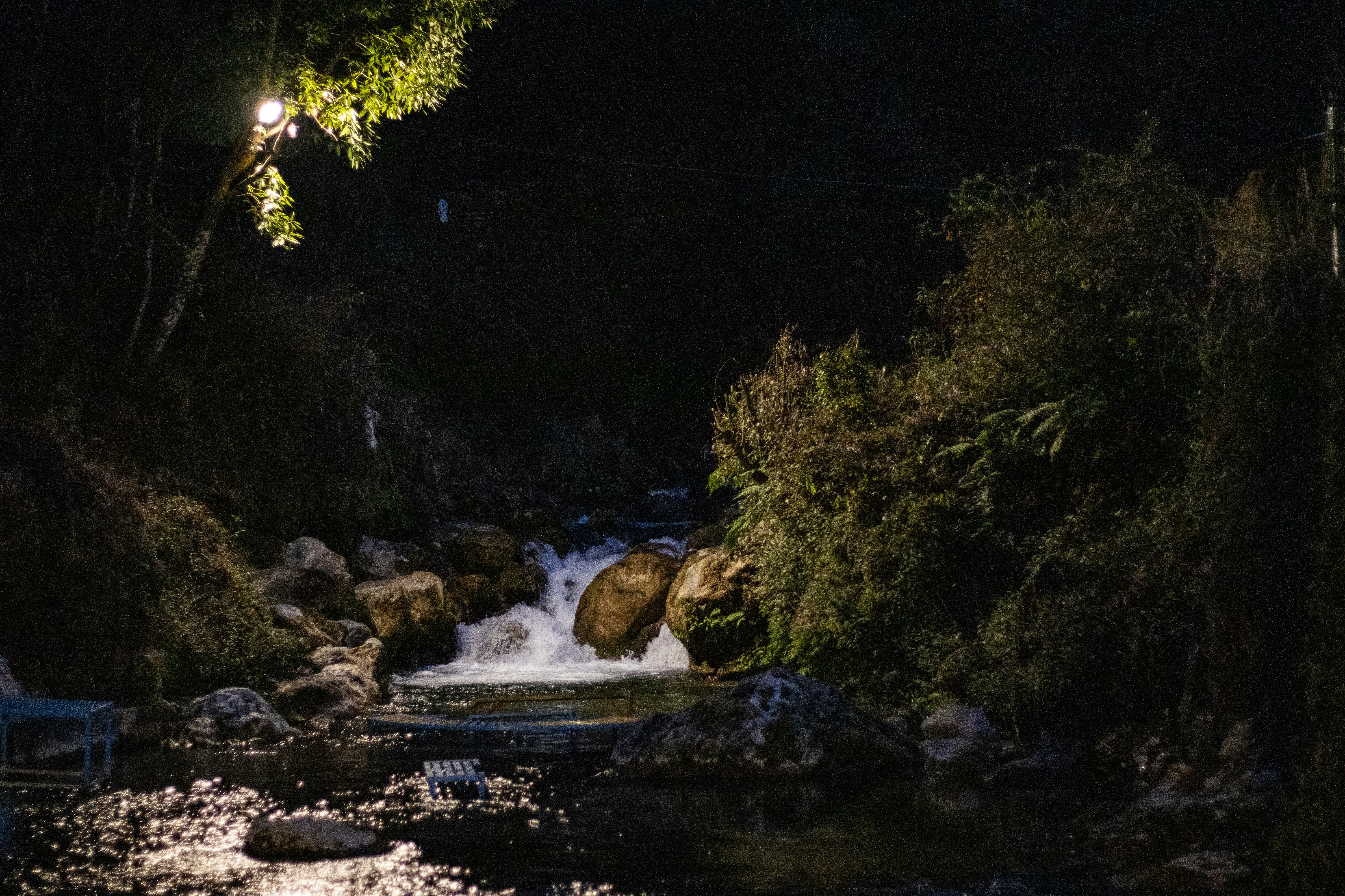Un arroyo atraviesa rocas por la noche