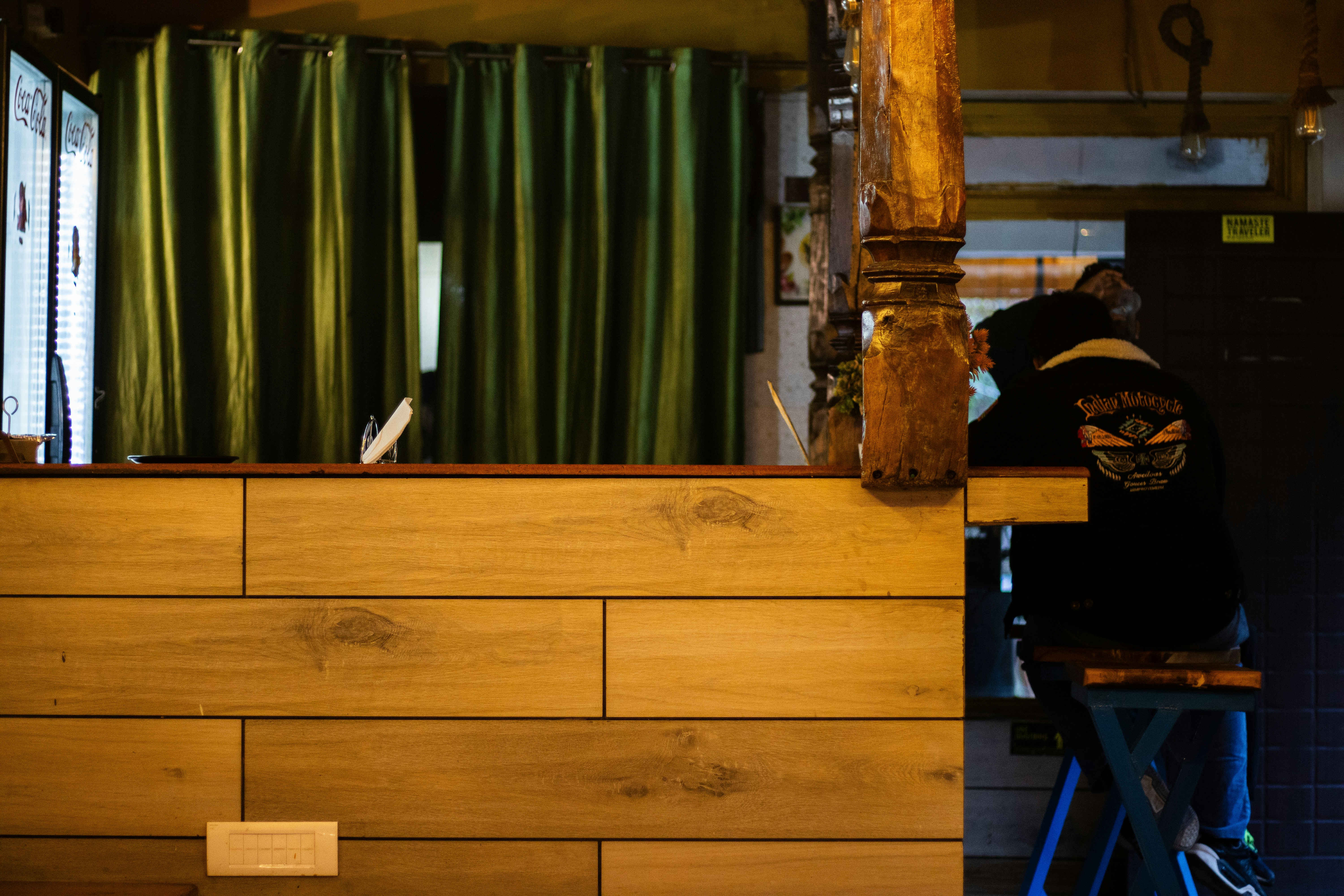 Person sitting at a wooden bar counter