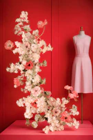 Pink dress and floral arrangement on red background