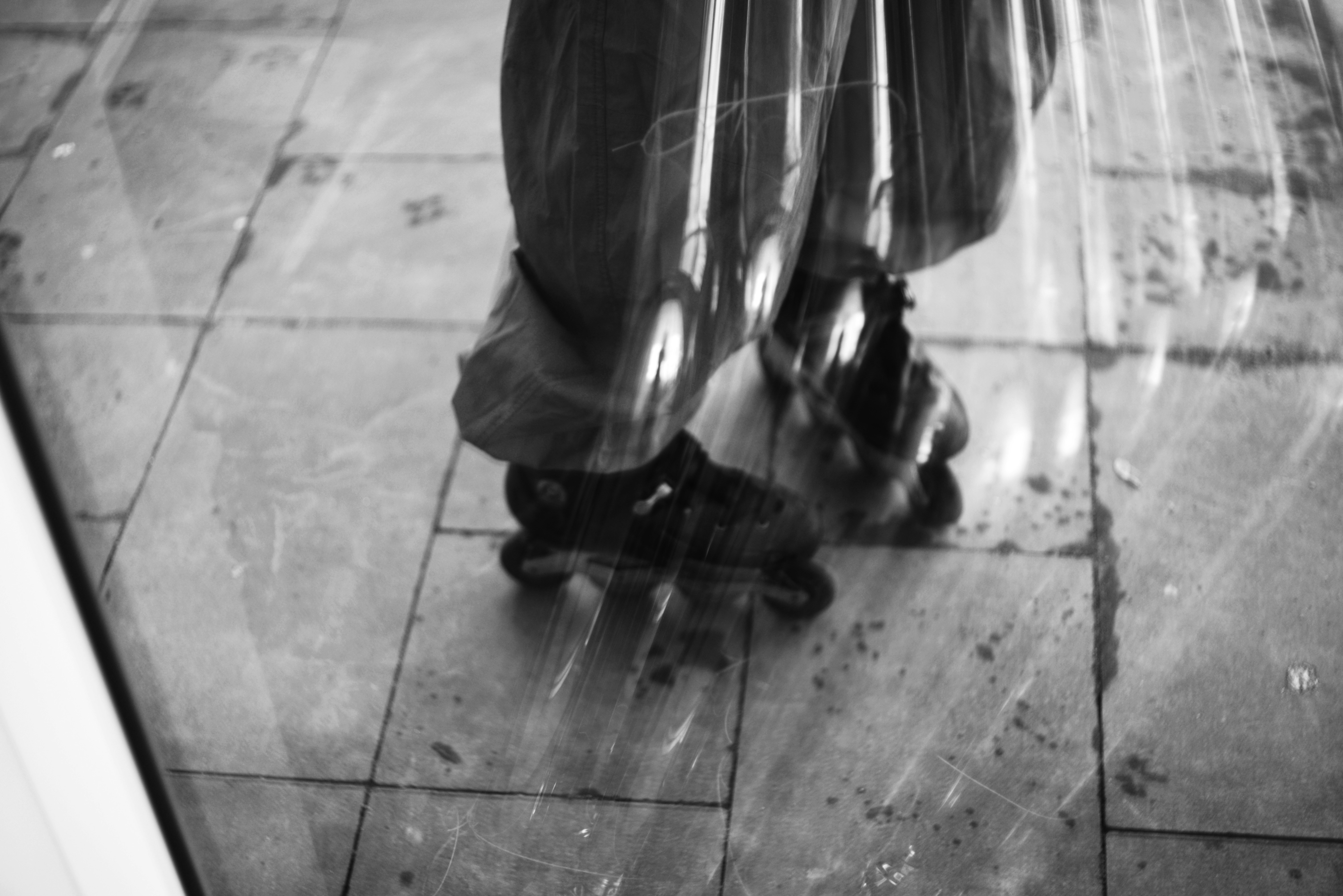 Patines en línea sobre suelo de baldosas reflejados en el cristal