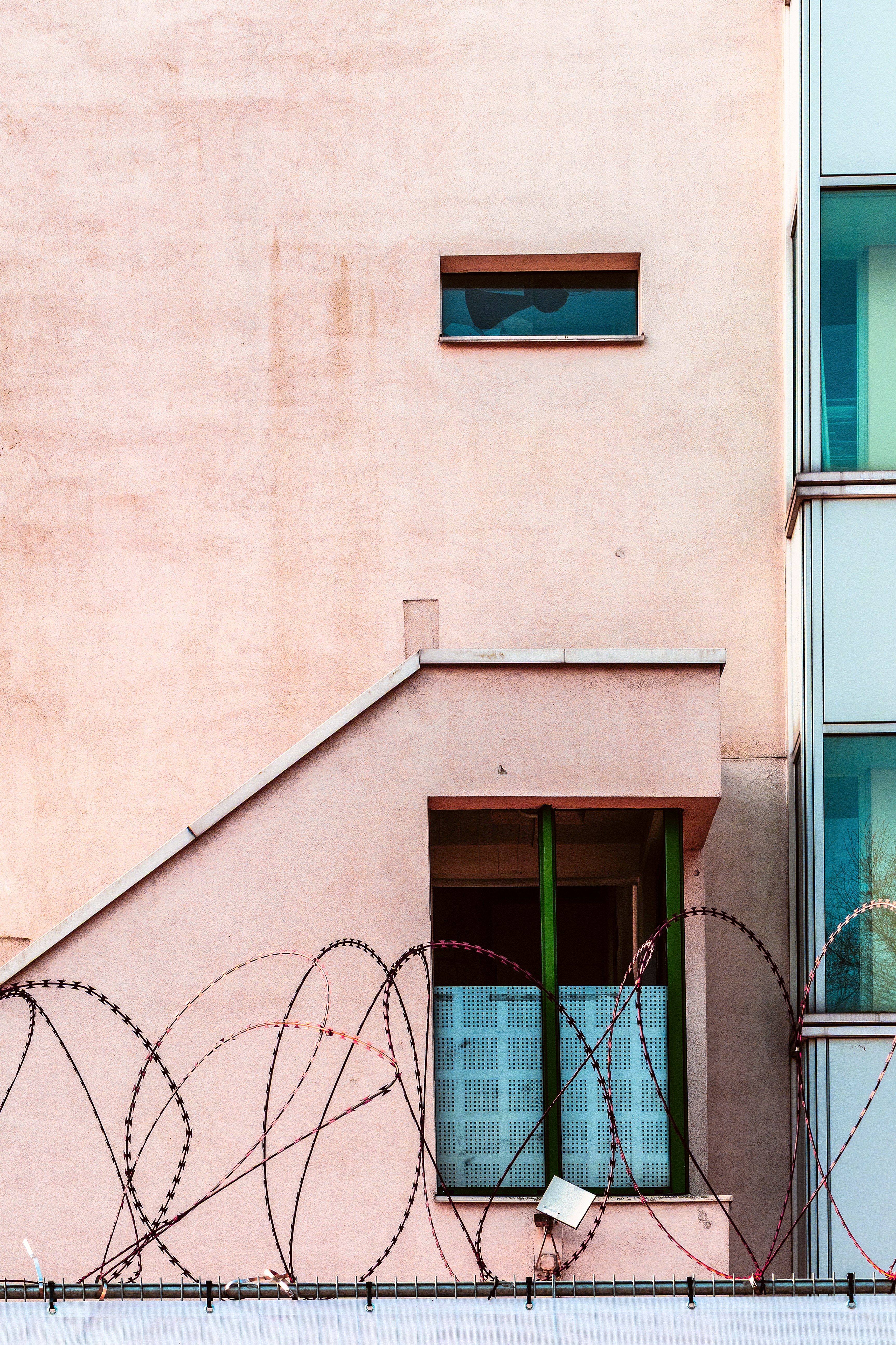 Pink building facade with barbed wire and windows