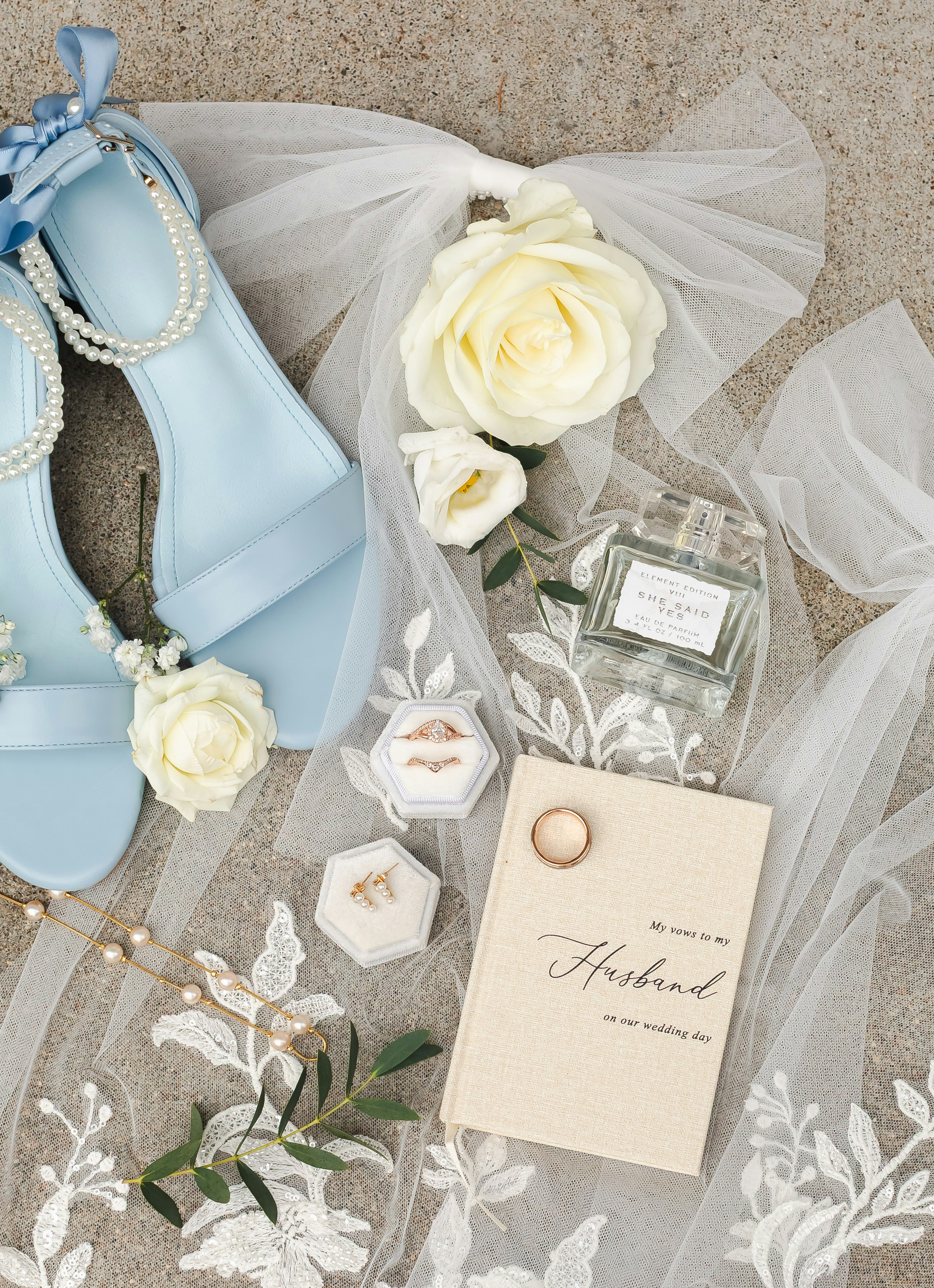 Hellblaue High Heels, Parfüm und Eheringe am Schleier.