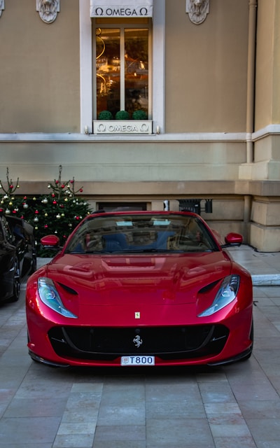 Red ferrari parked in front of a building