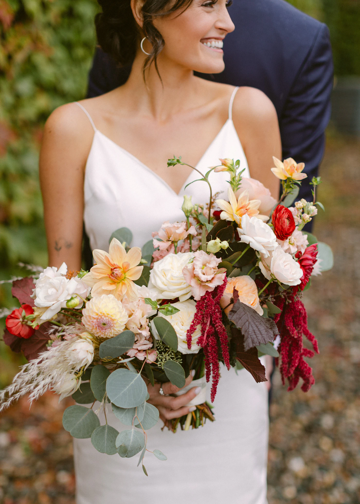 How to finance your dream wedding responsibly — A bride holding a lush floral bouquet at a spring wedding venue.