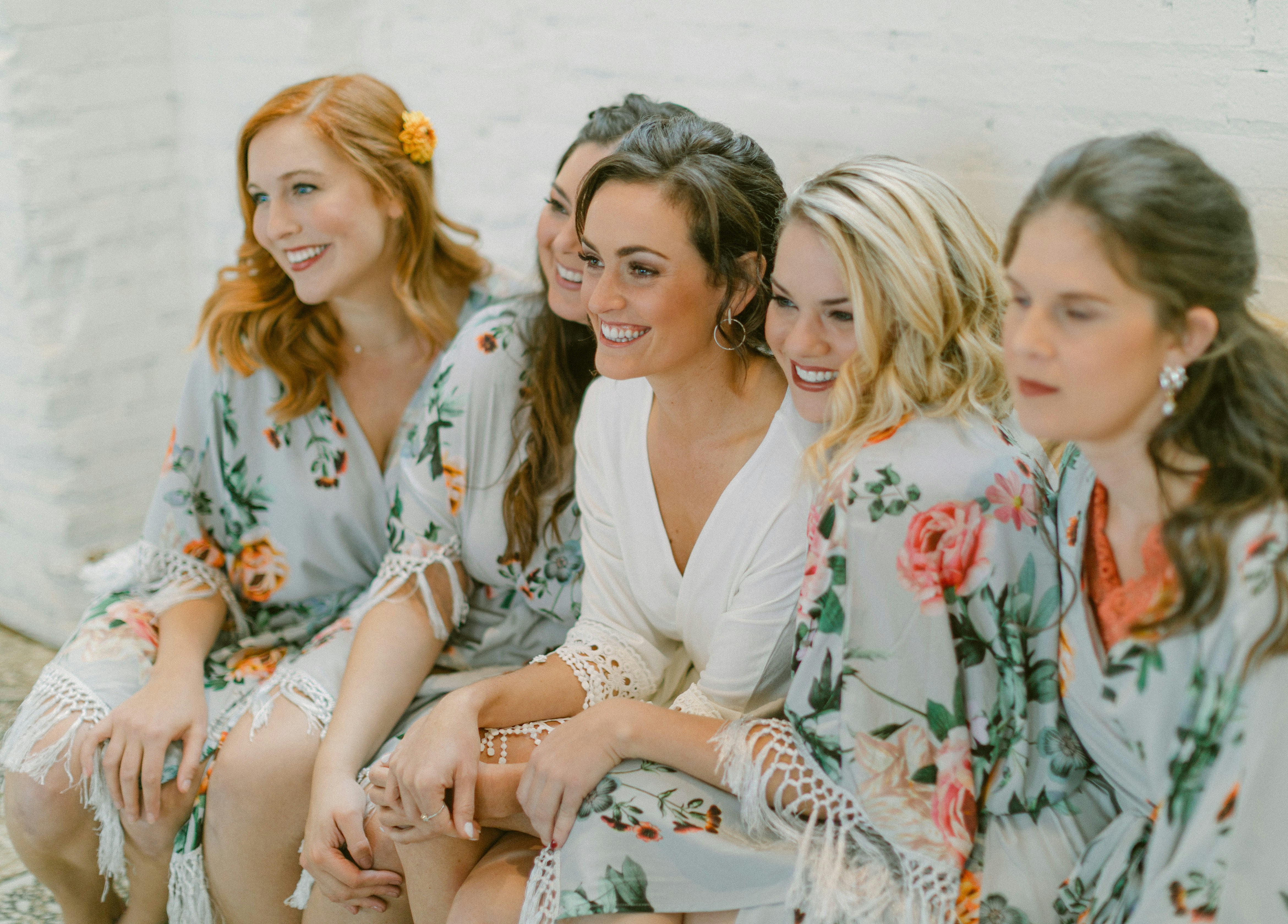 Cinq femmes en robes florales souriant ensemble