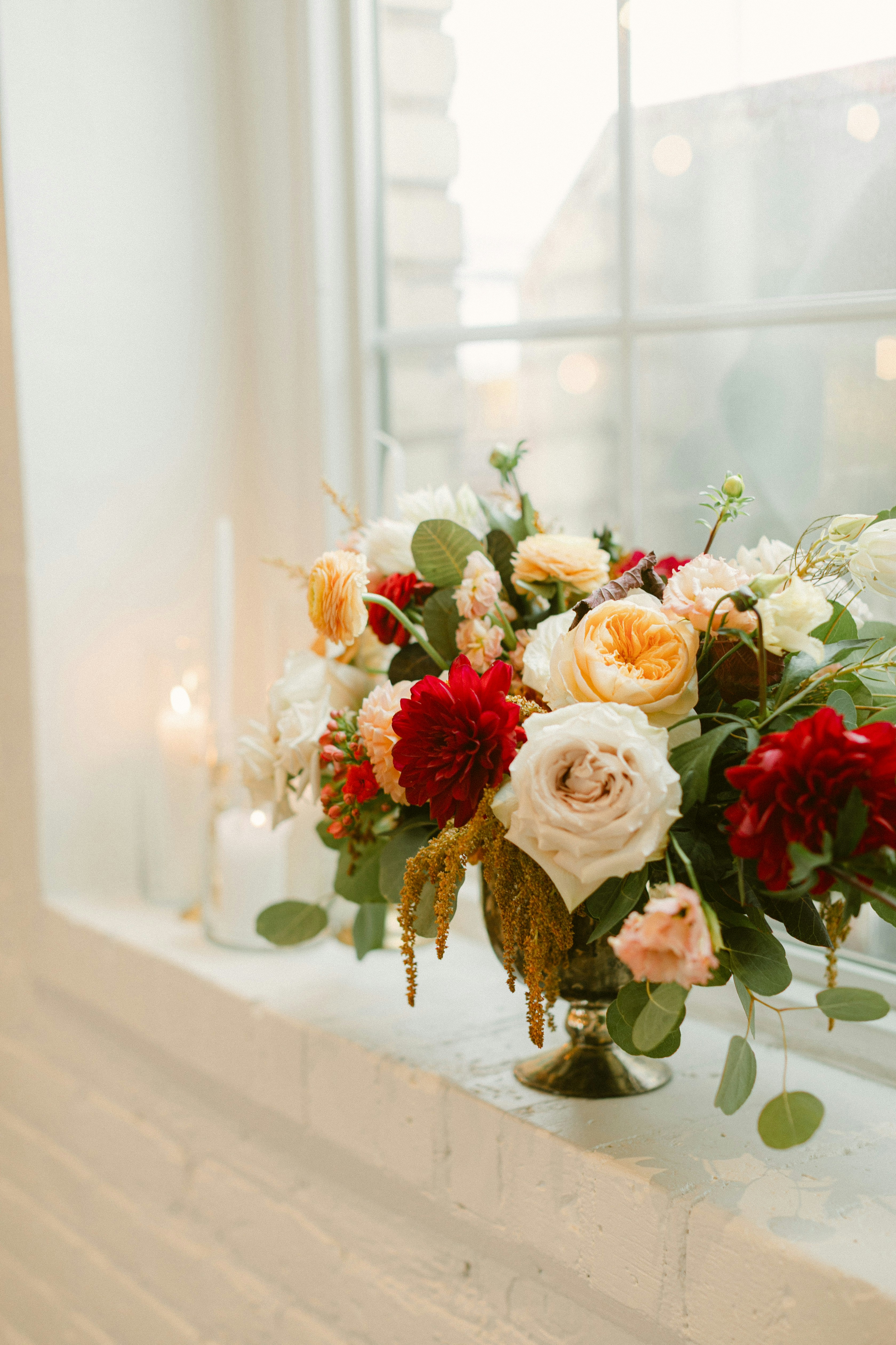 Un magnifique arrangement floral est posé sur un rebord de fenêtre.