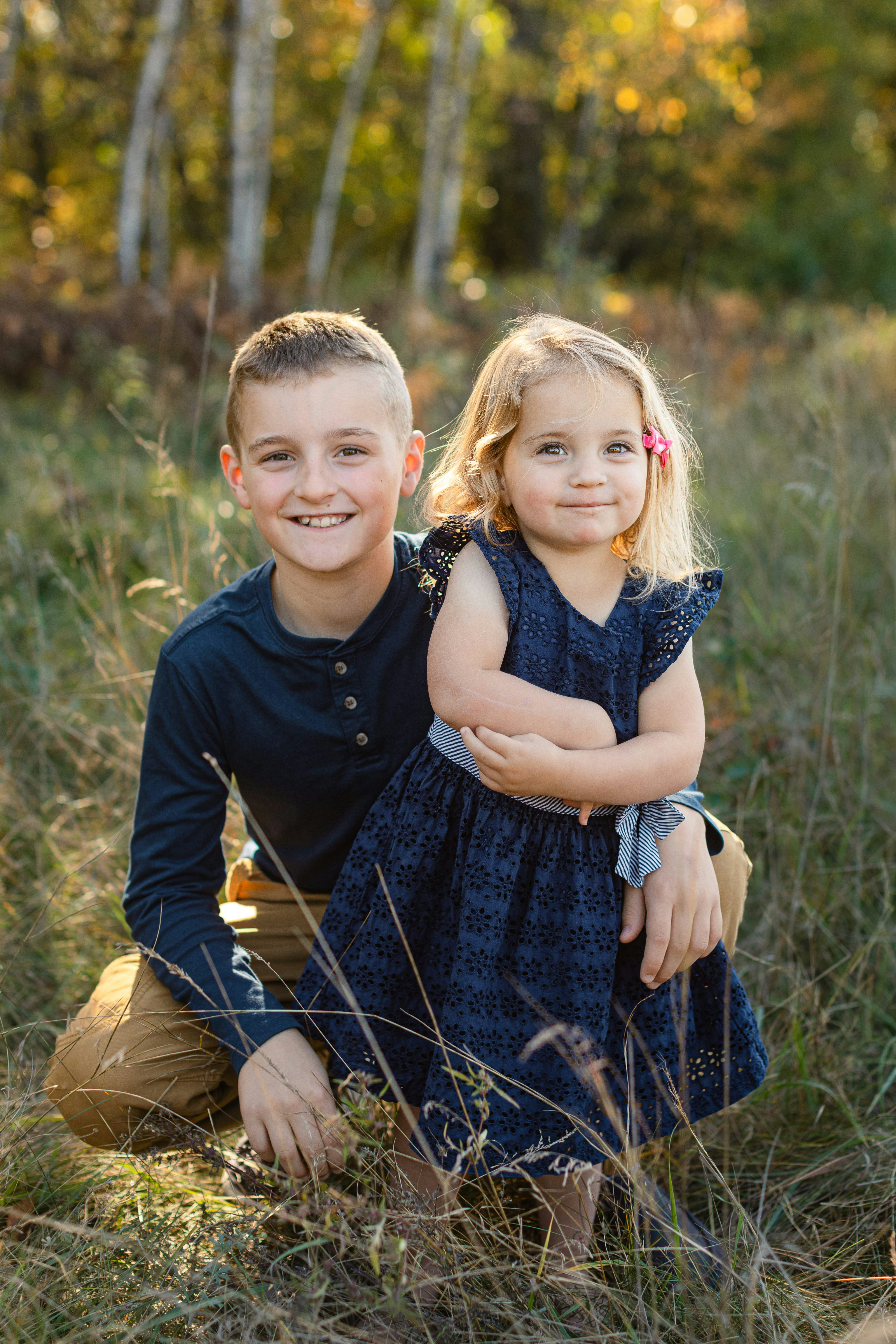 Frère et sœur souriant dans un champ