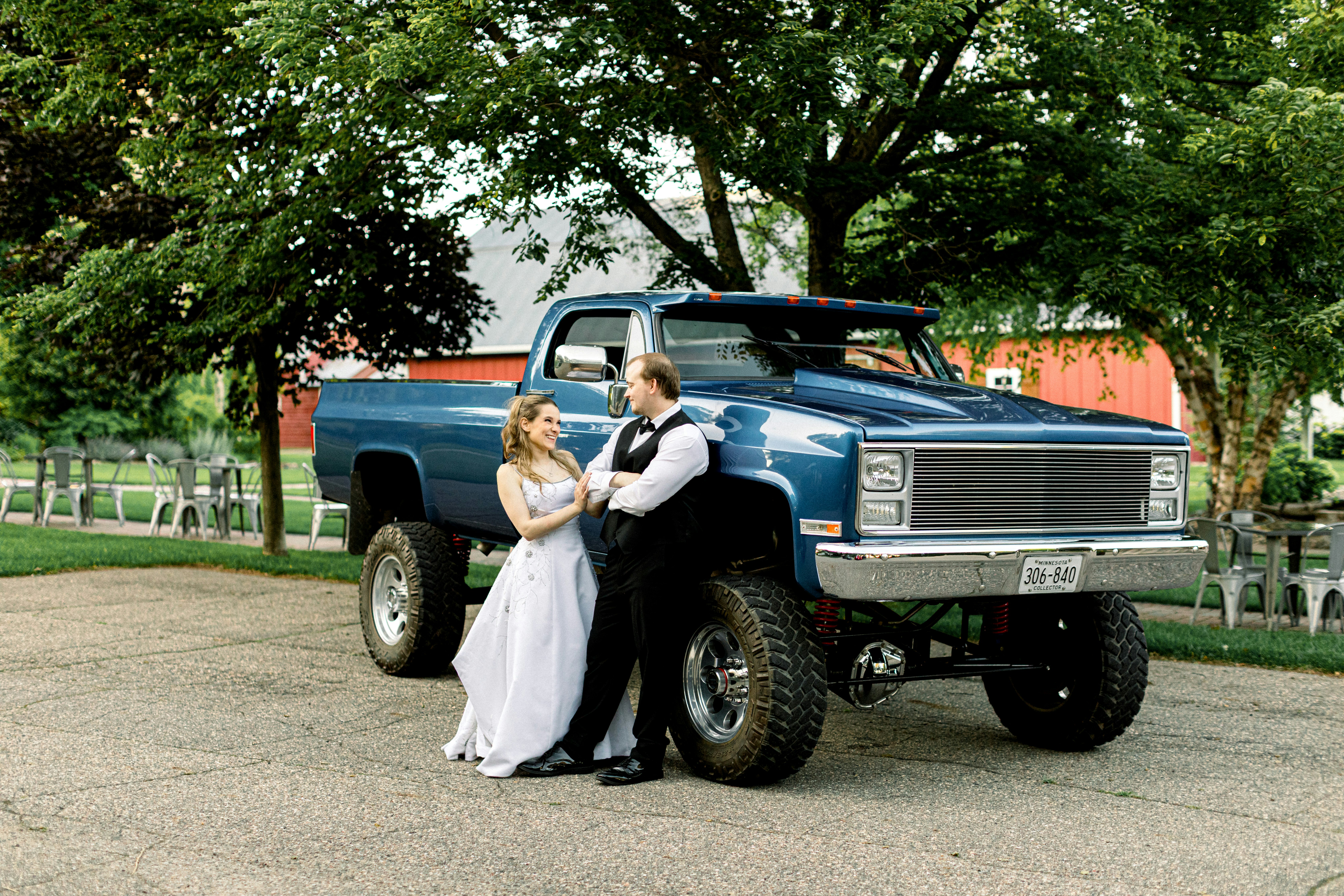 Posez en couple avec un pick-up bleu surélevé.