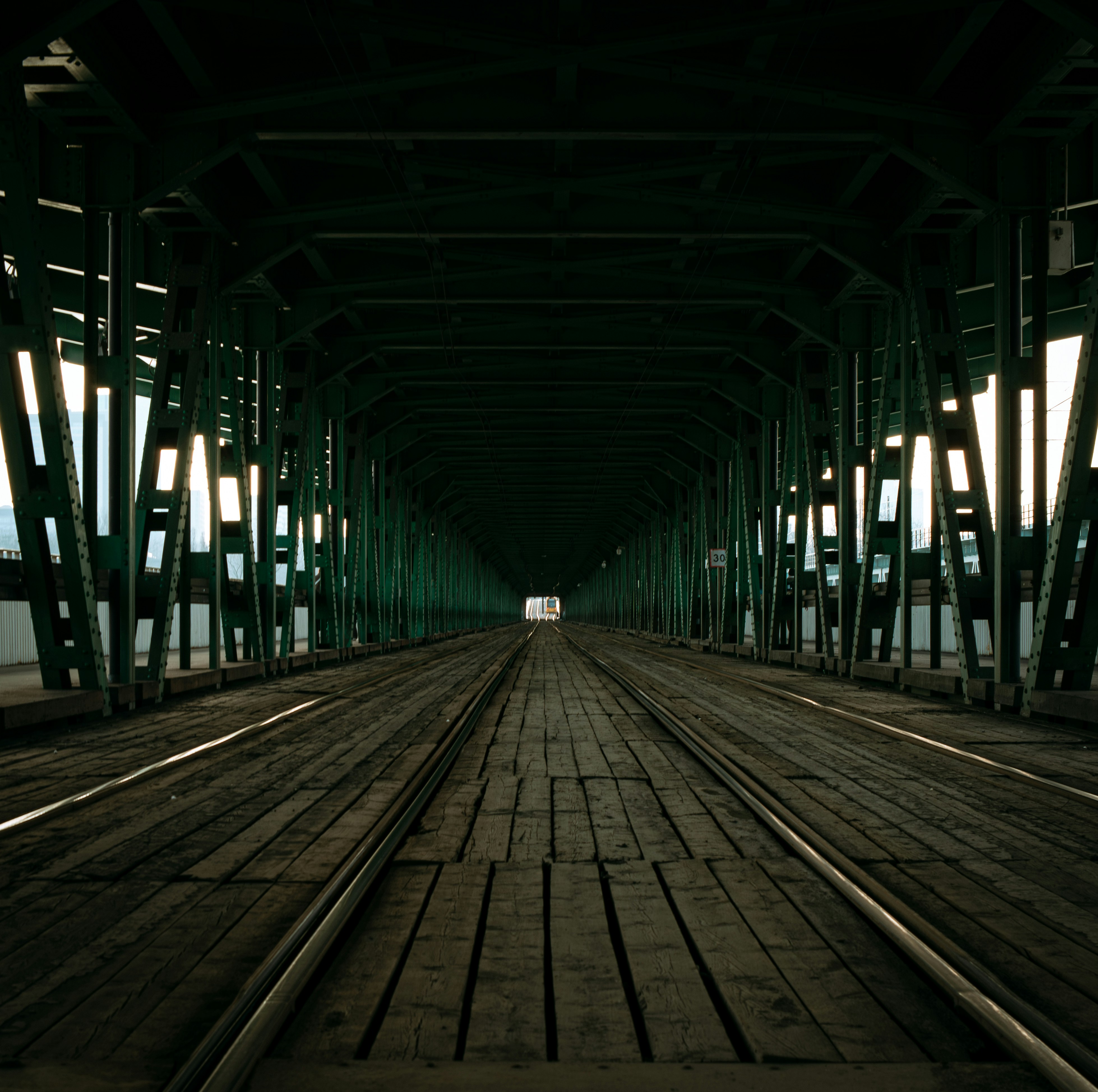 Dark industrial bridge with wooden planks and tracks