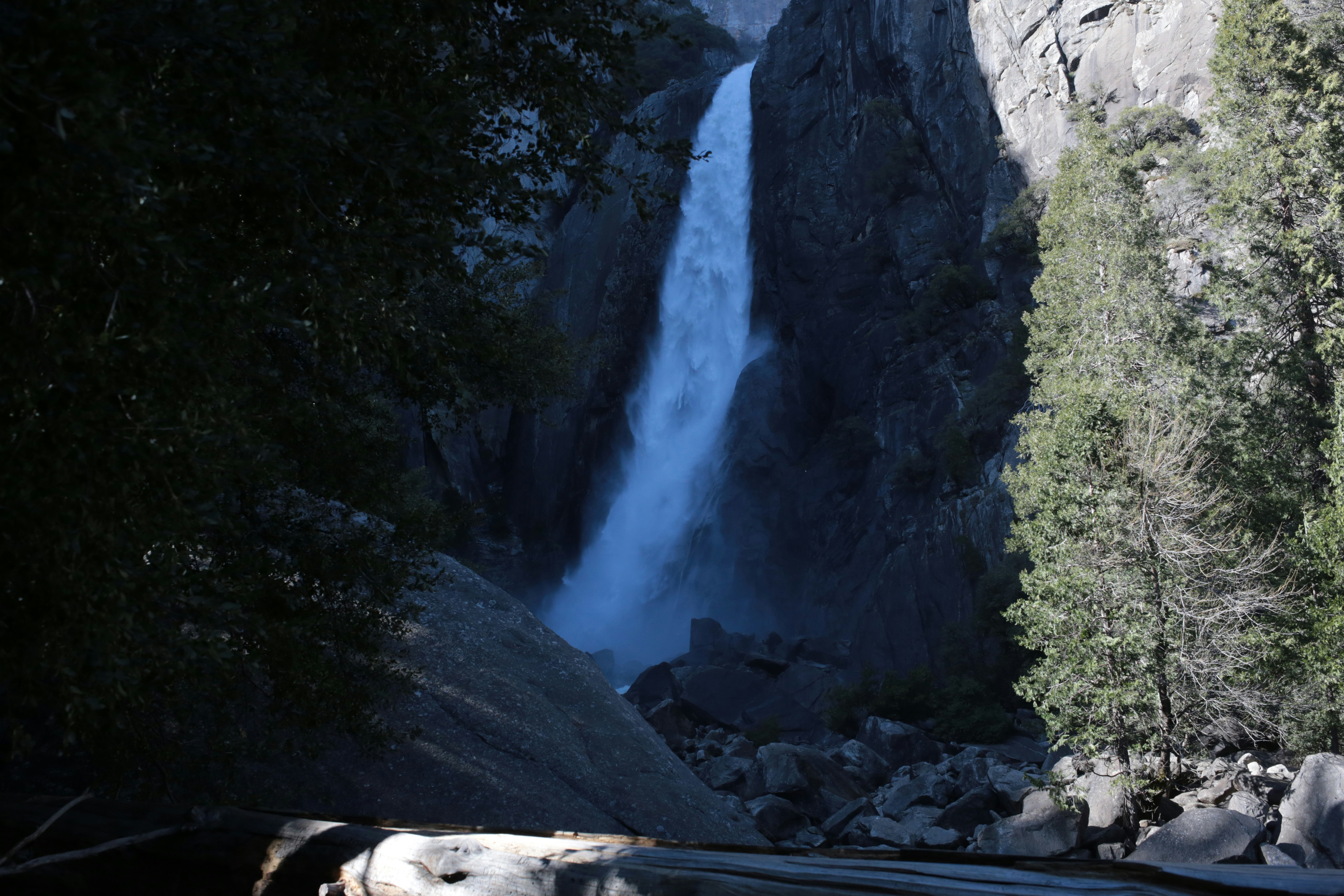 A tall waterfall cascades down a rocky cliff face.