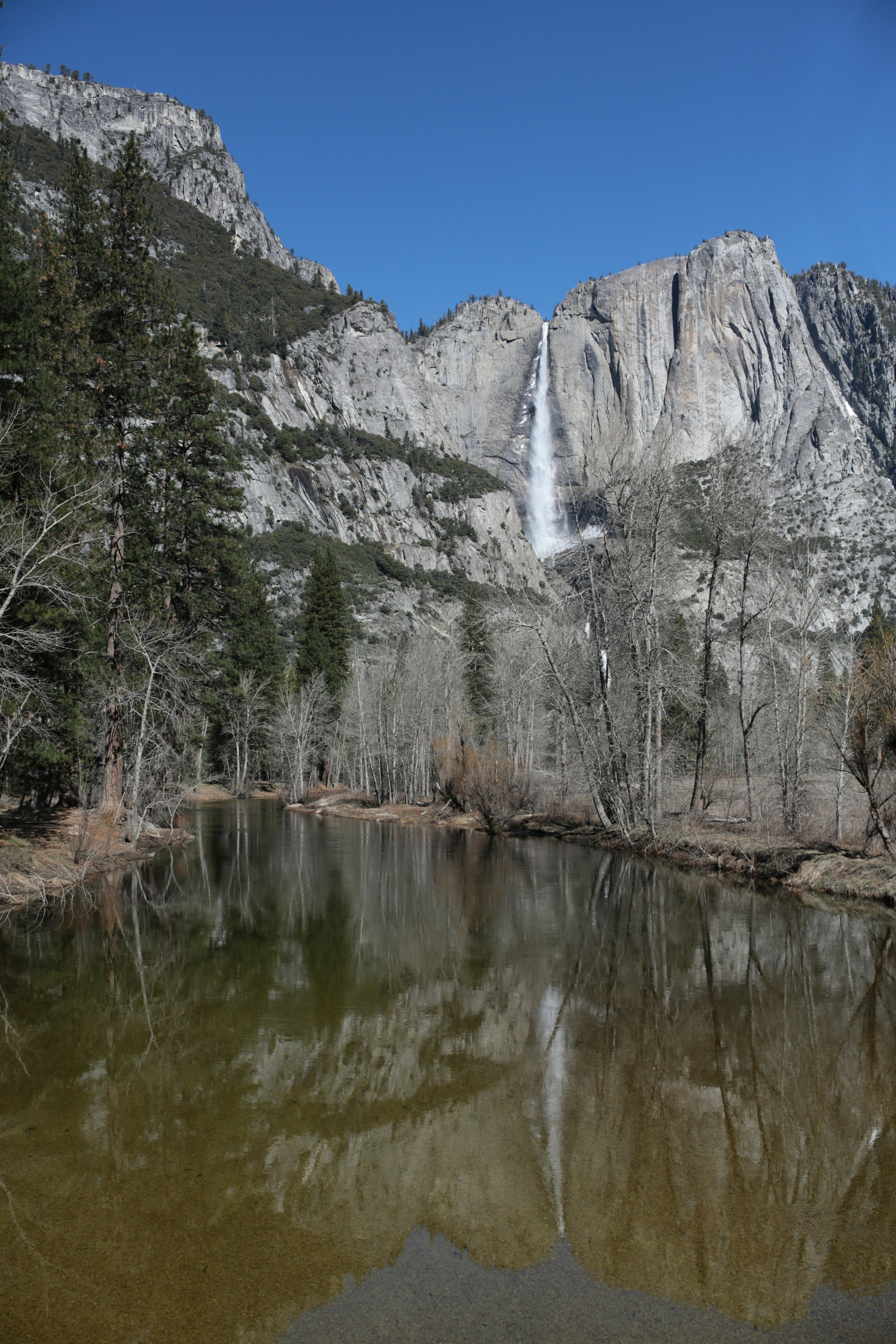 Waterfall cascading down a rocky cliff reflected in water