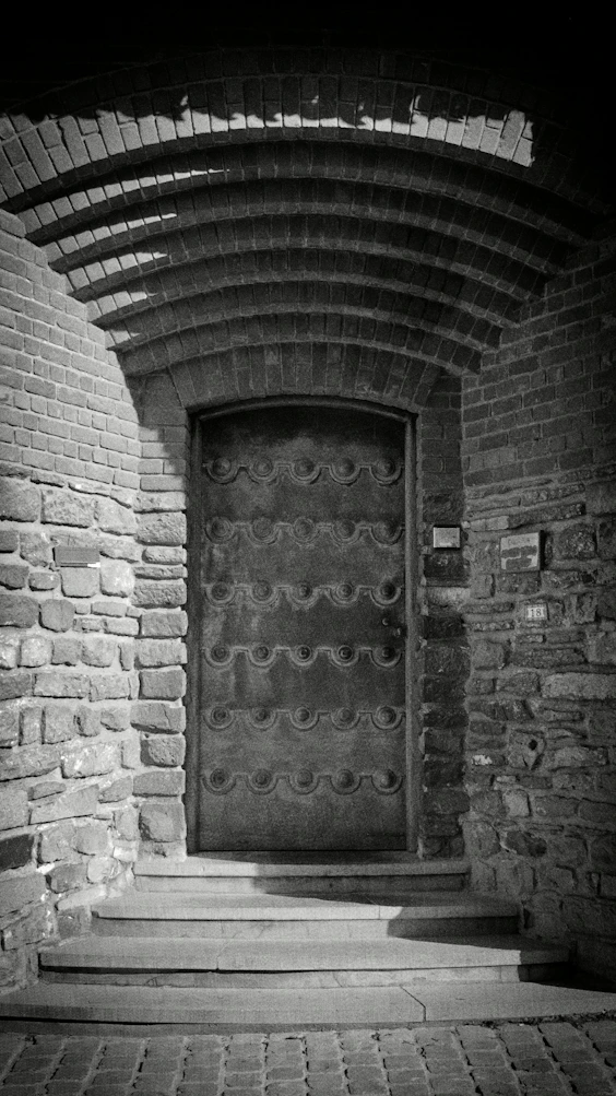 Ornate metal door set in a stone archway.