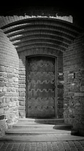 Ornate metal door set in a stone archway.
