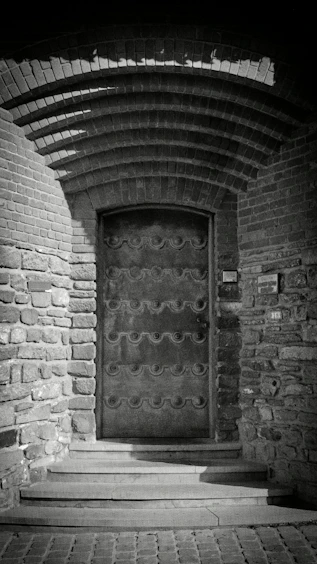 Ornate metal door set in a stone archway.