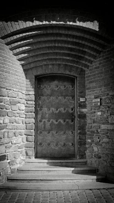 Ornate metal door set in a stone archway.