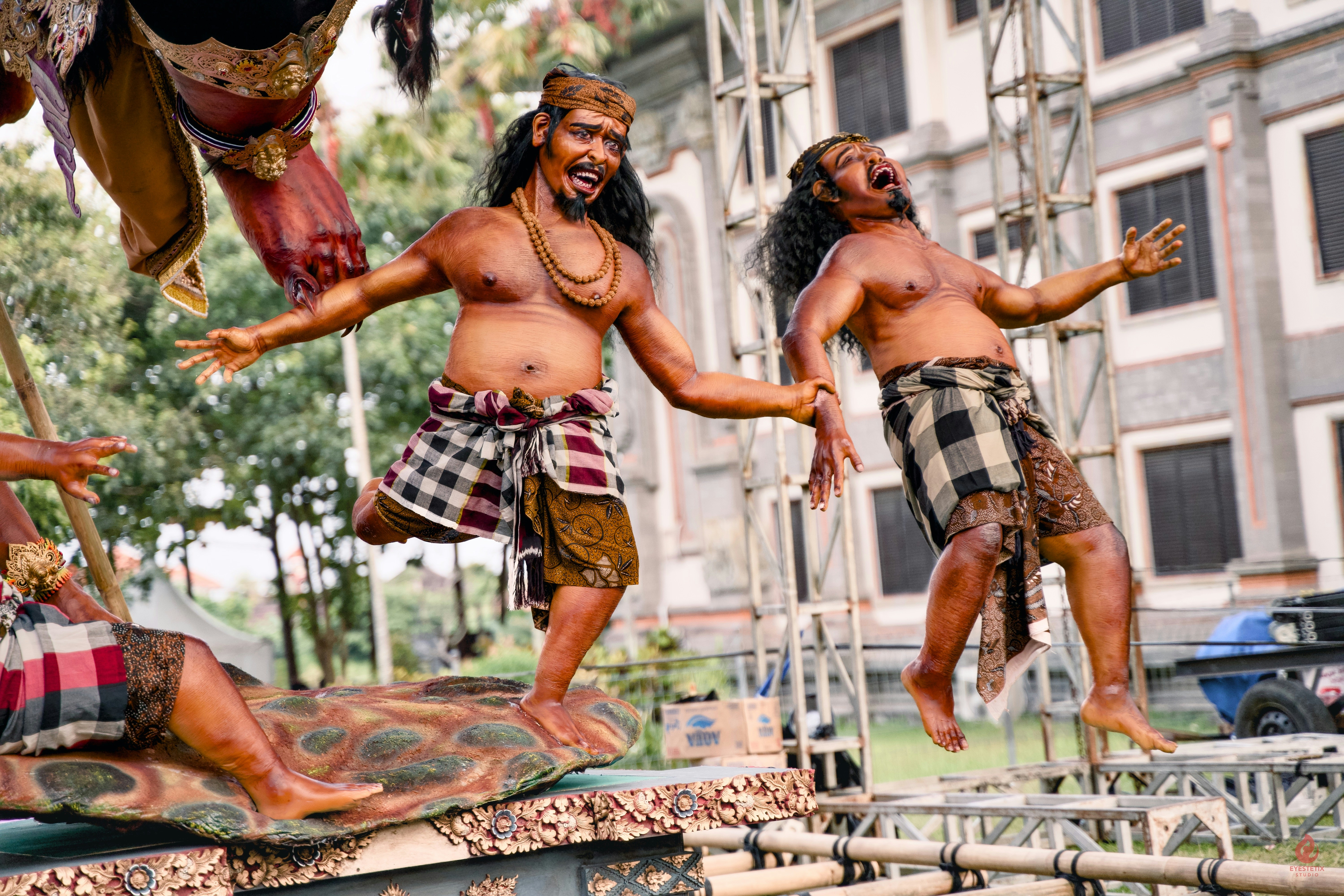 Two men in traditional attire performing a dance