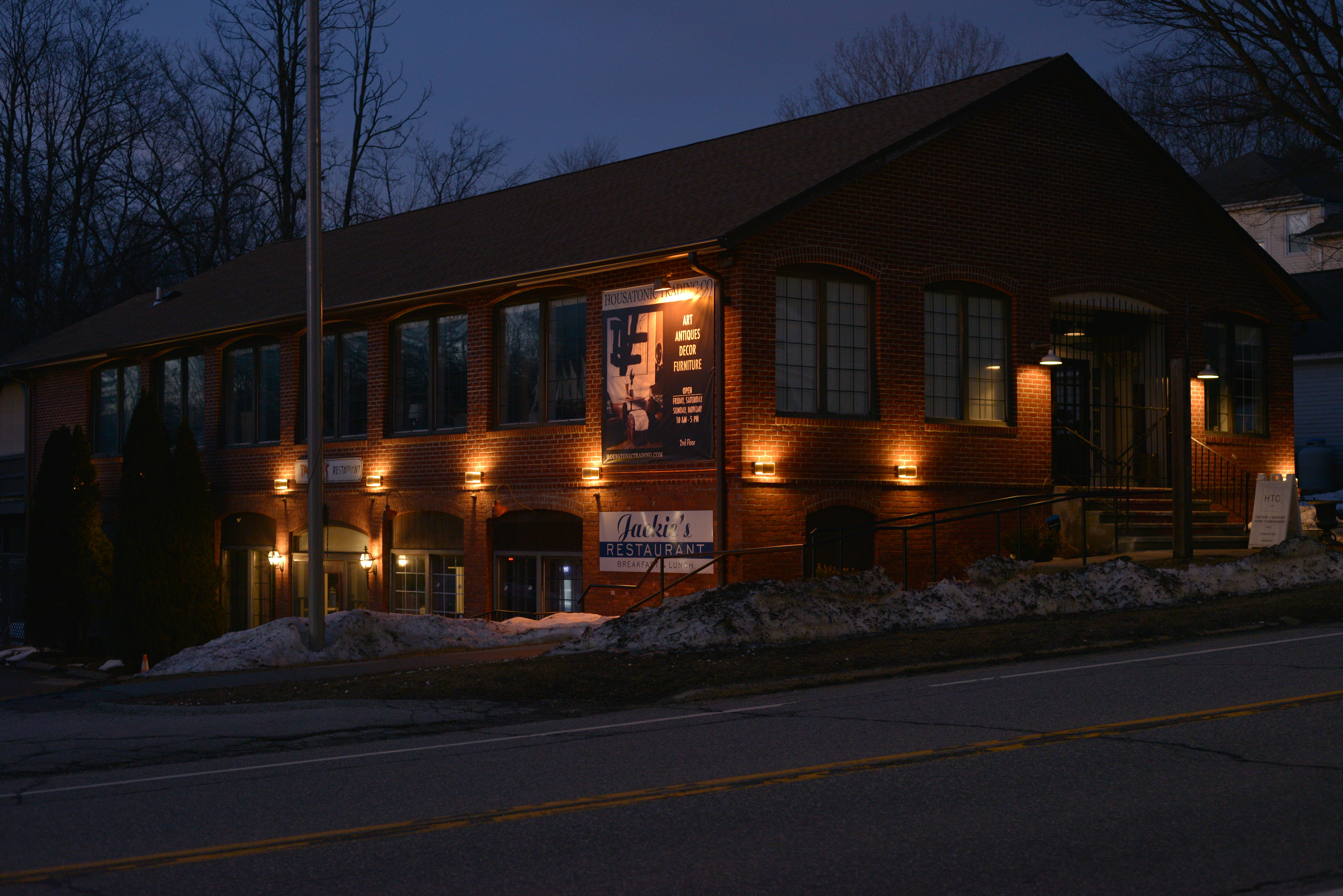 Ein Holzgebäude mit eingeschaltetem Licht bei Einbruch der Dämmerung