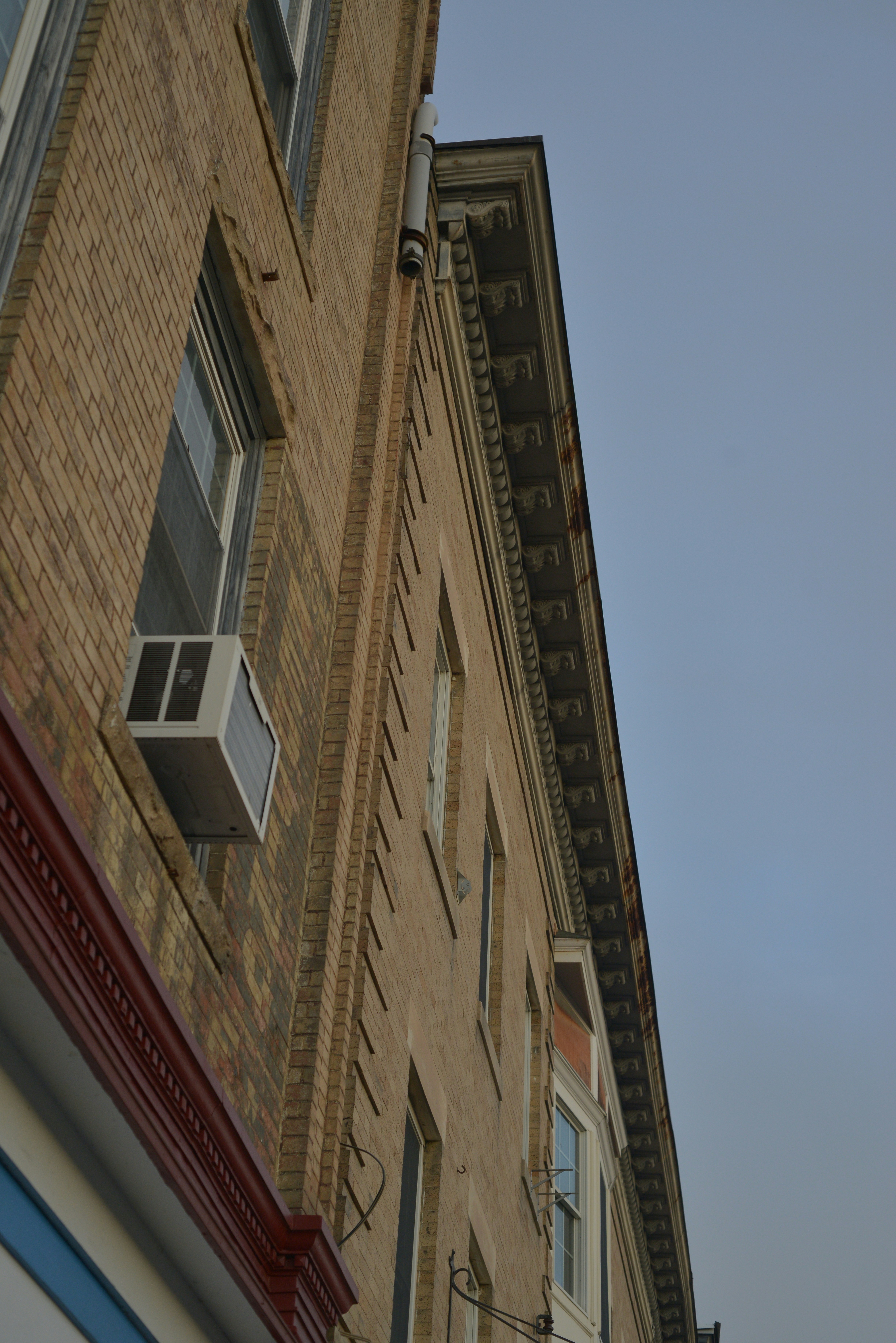 Nahaufnahme einer Backsteingebäudefassade mit Fenstern.