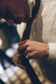 Man in a white shirt tying a tie