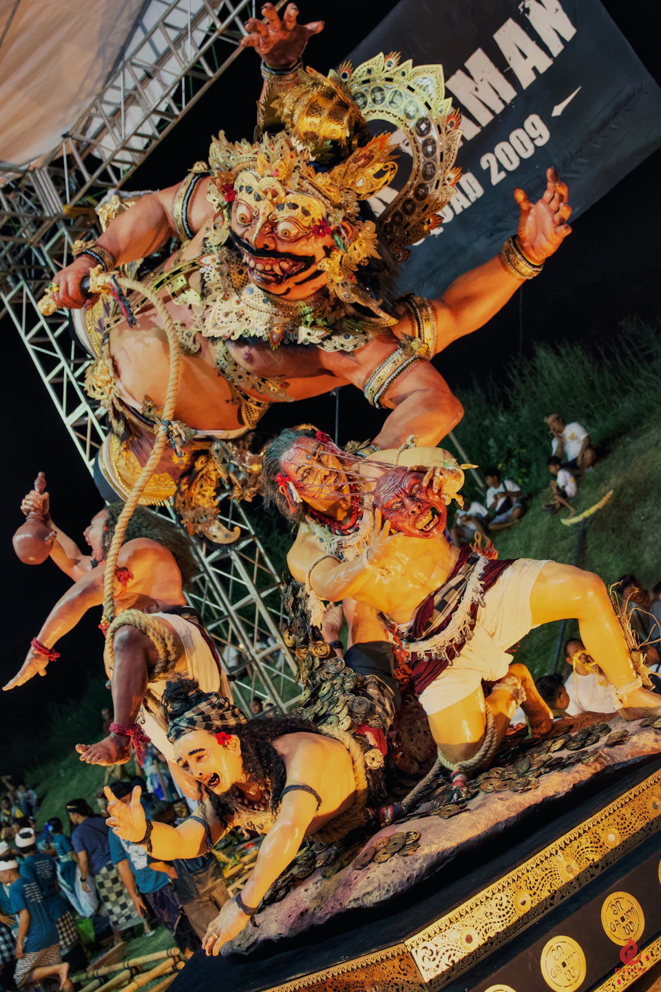 An intricate Balinese Ogoh-Ogoh effigy: a giant papier-mâché demon figure with elaborate painting and costume, paraded through the streets on the night before Nyepi to purify the island of negative spirits