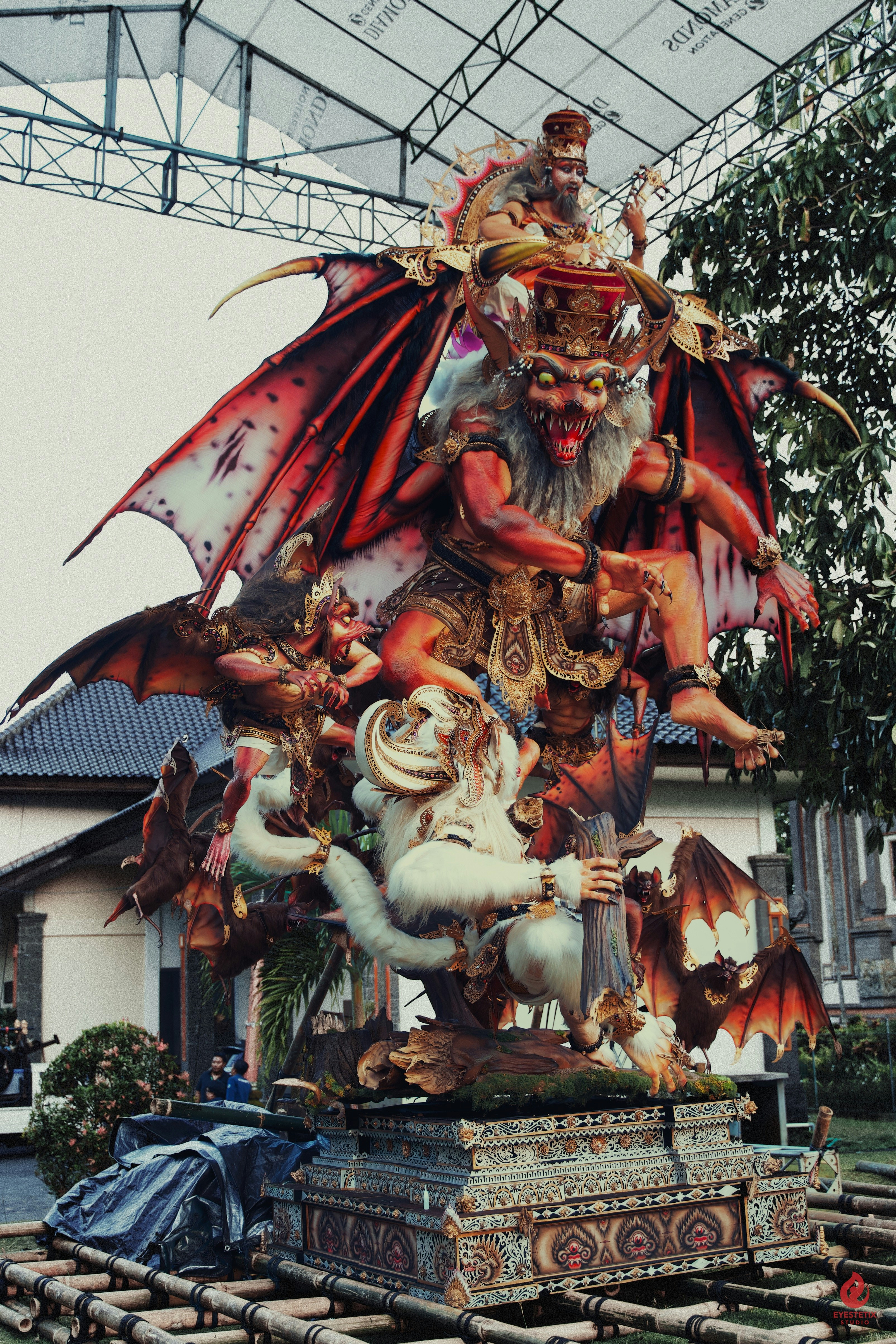 Intricate demonic effigy with wings and multiple figures.