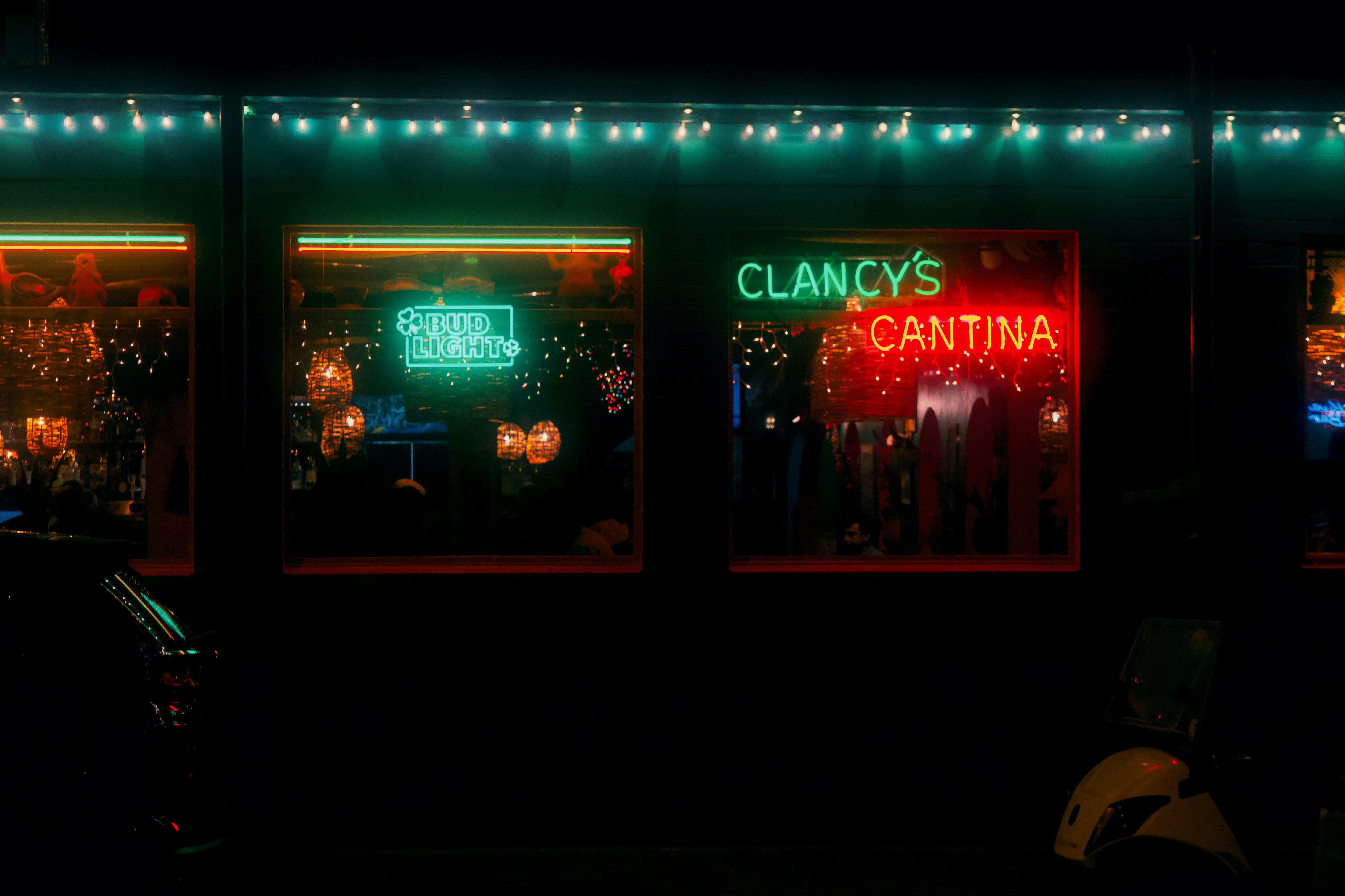 Neon signs glow brightly on a building at night.