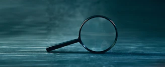 A magnifying glass rests on a textured surface.