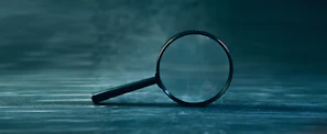 A magnifying glass rests on a textured surface.