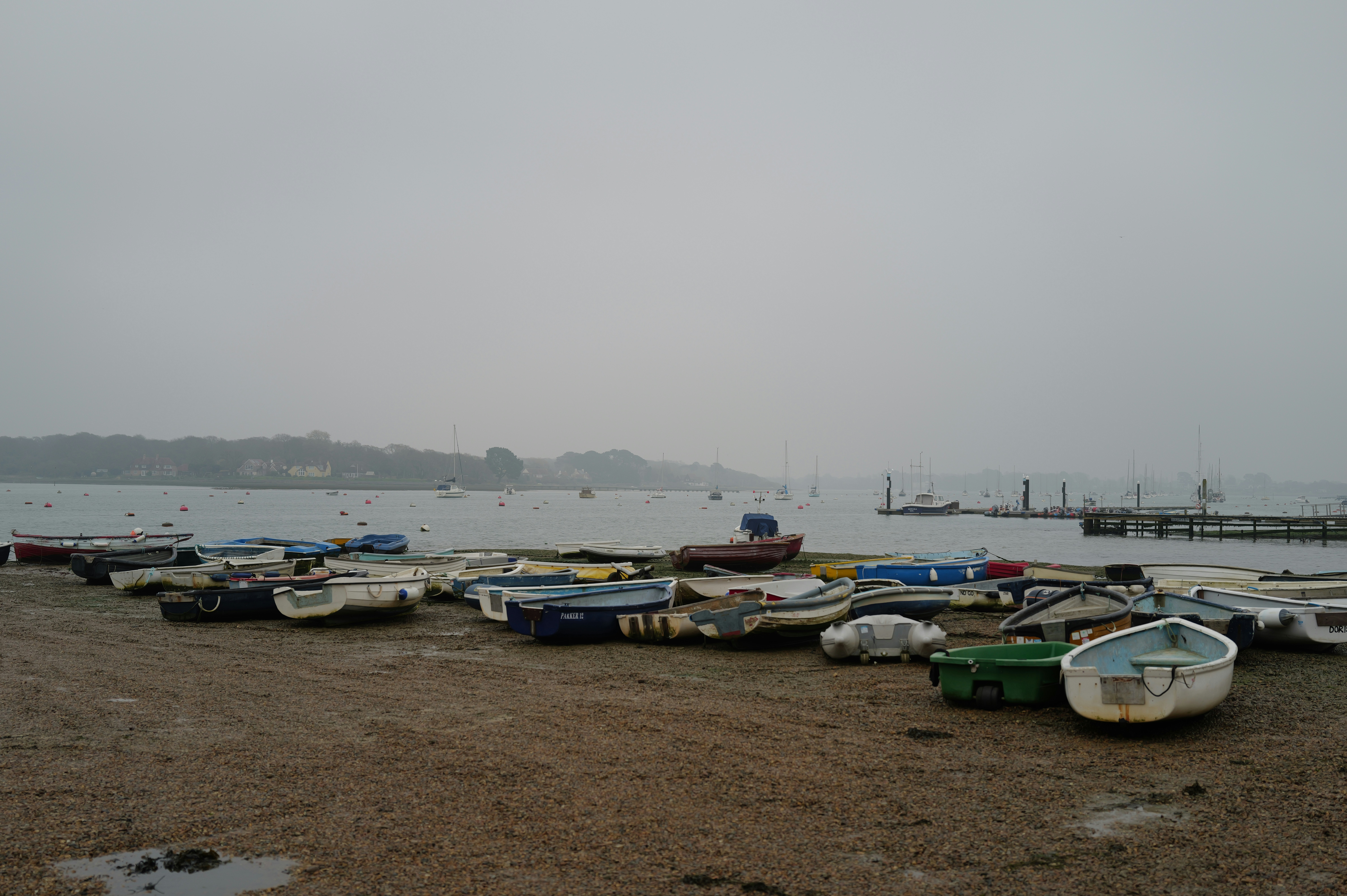 Many small boats resting on a sandy shore