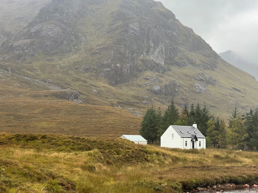Small white house in a misty Scottish glen