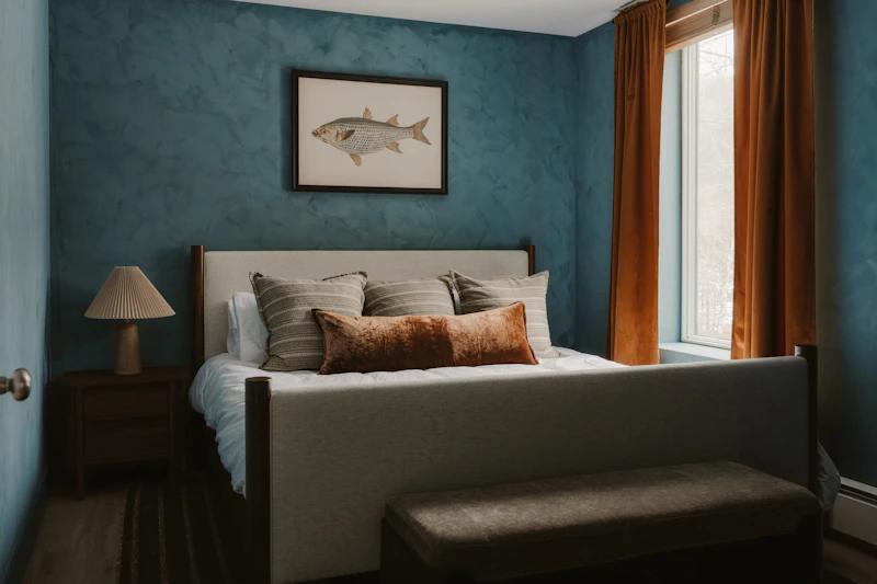 Quarto real com parede texturizada em azul-marinho e cama de casal