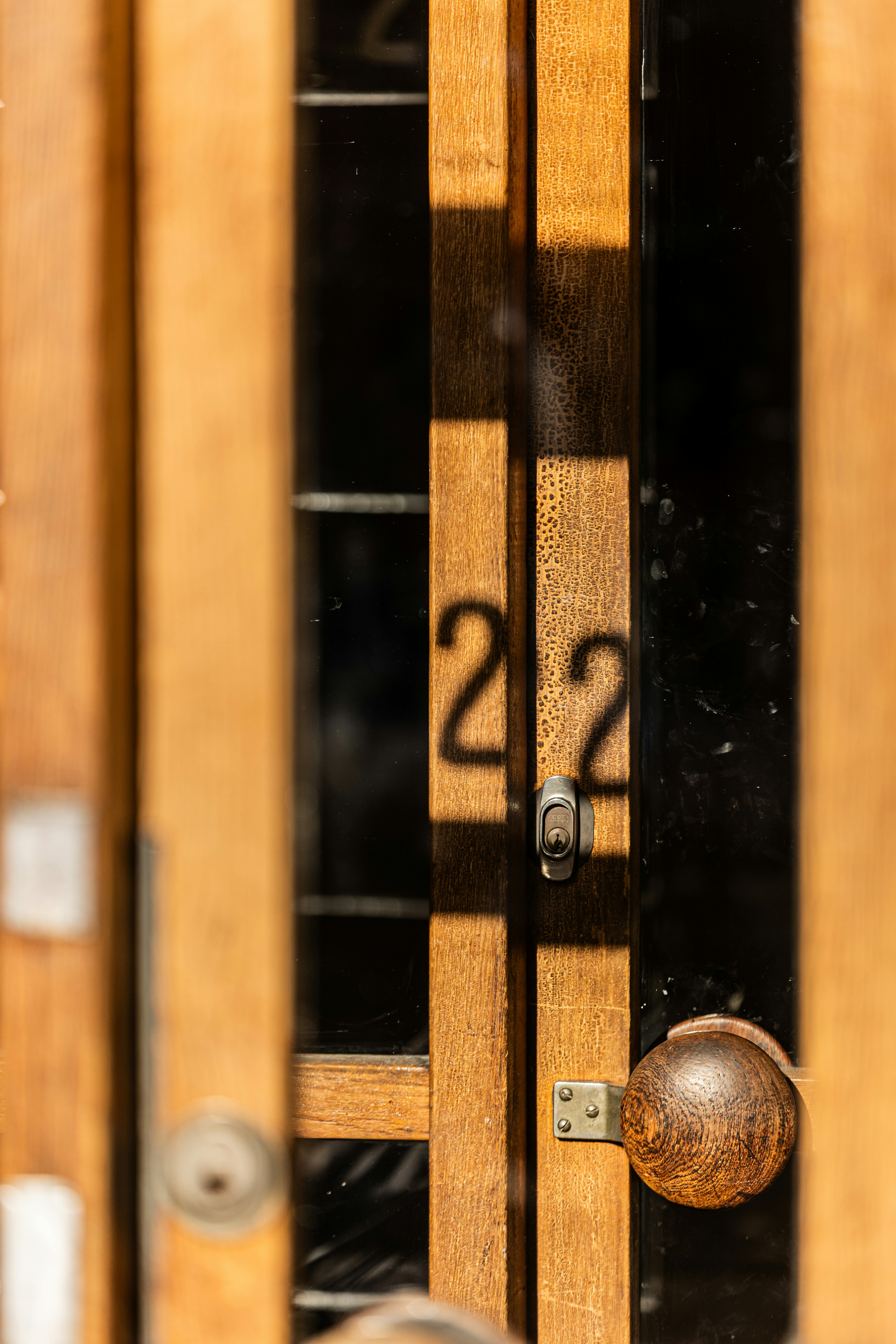 Wooden door with the number 22 reflected on glass