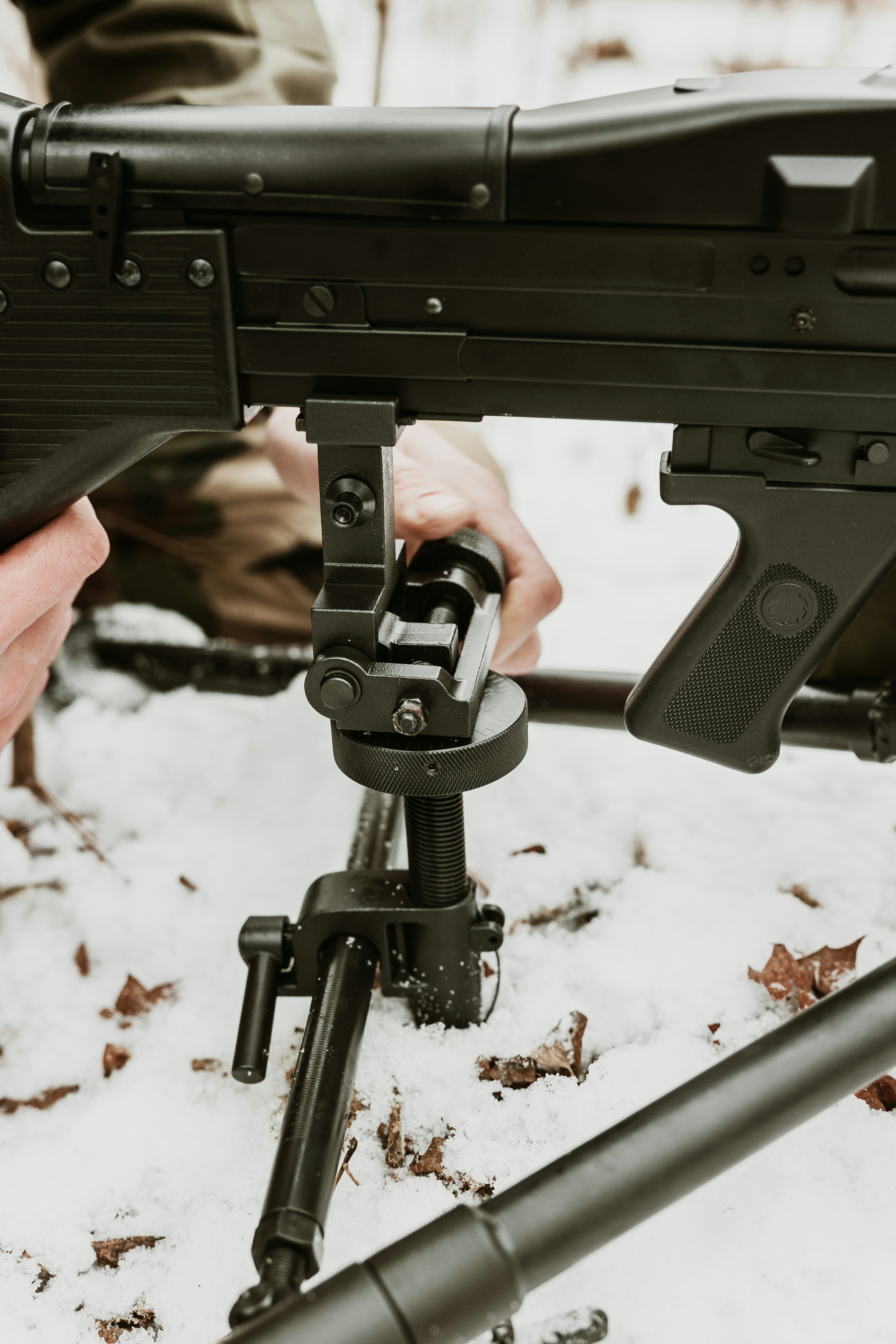 Soldat montiert ein Maschinengewehr auf einem Stativ im Schnee.