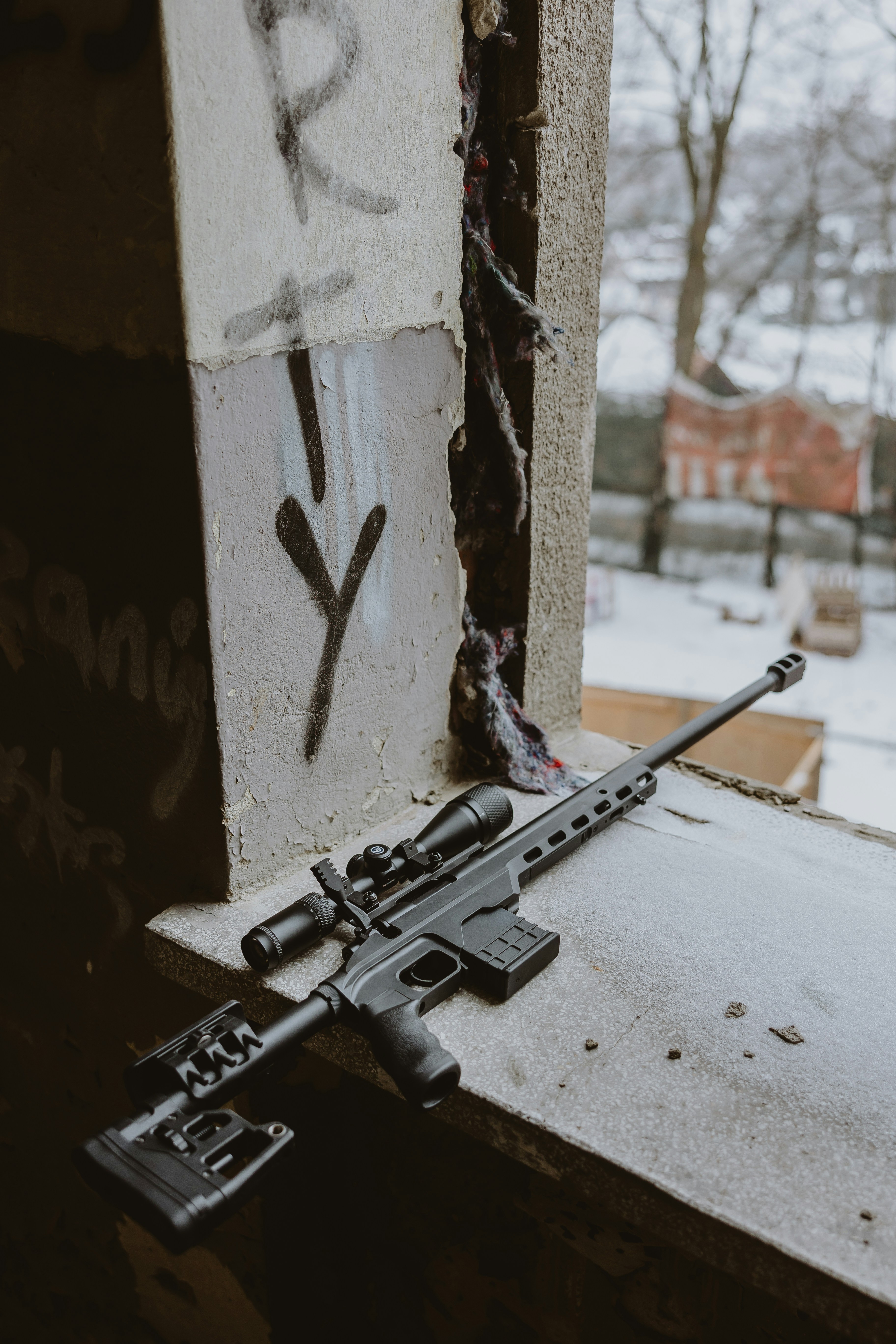 Scharfschützengewehr mit Zielfernrohr ruht auf der Fensterbank