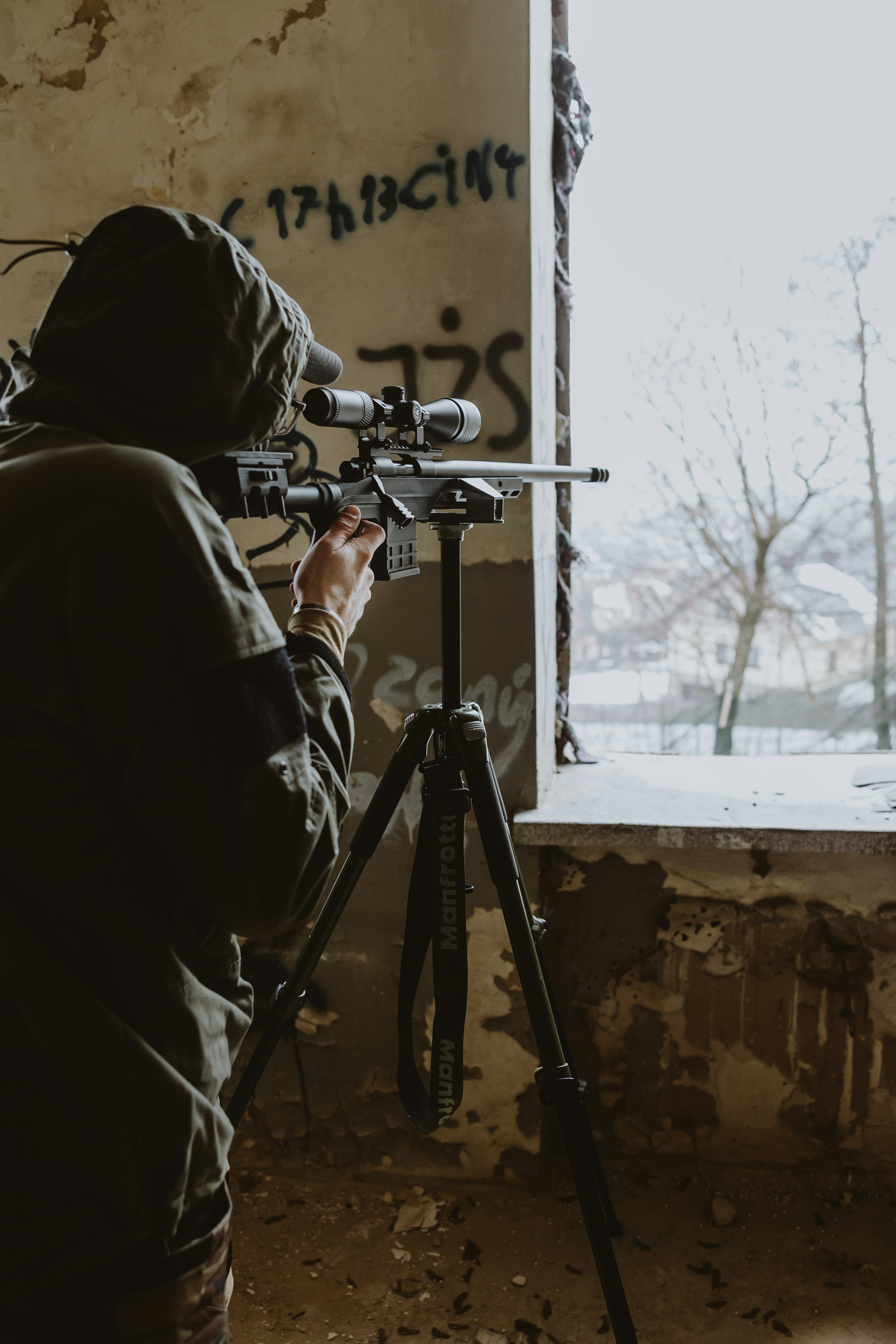 Person, die mit Zielfernrohr auf dem Stativ zielt