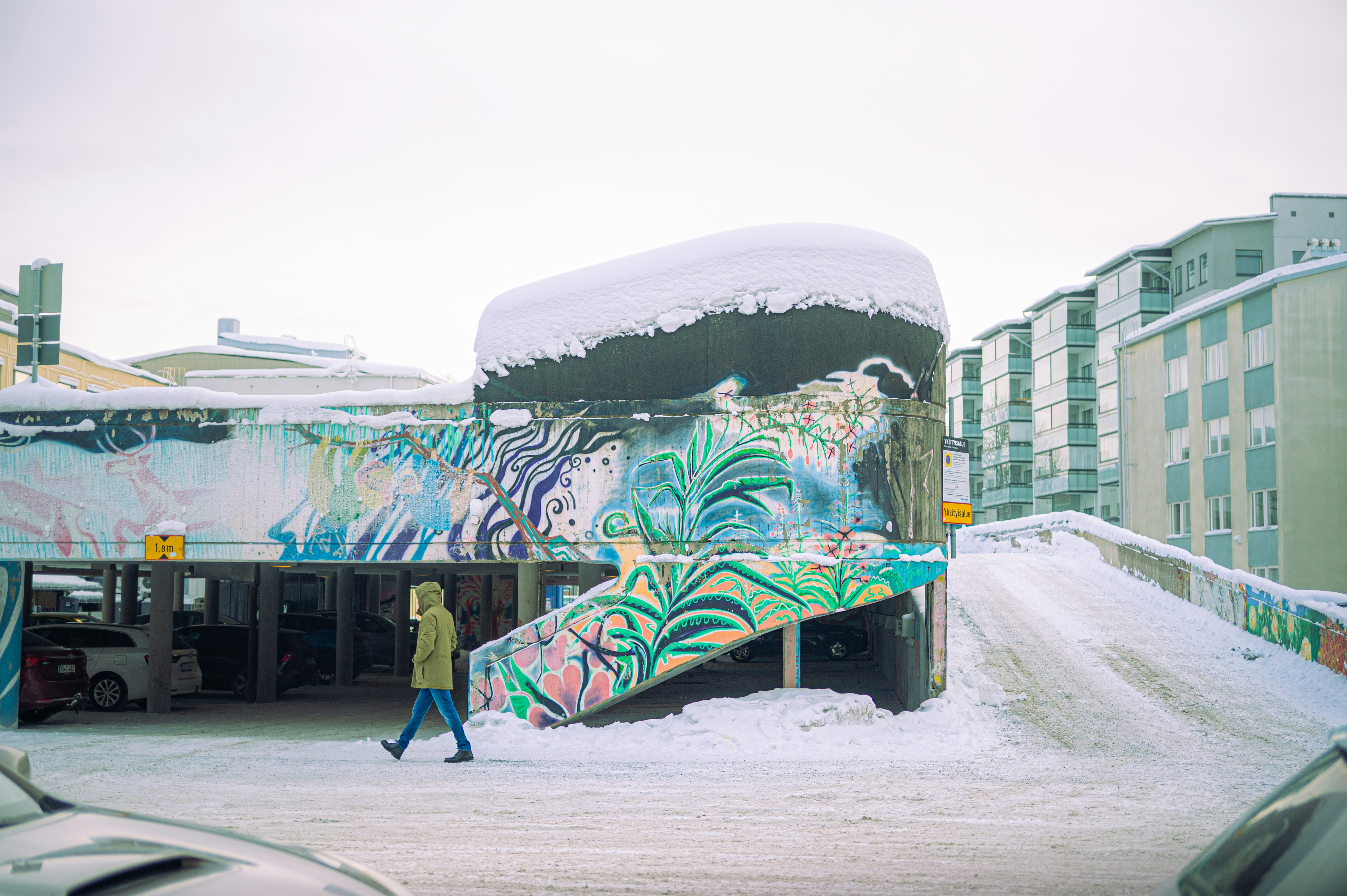 Person walks past colorful mural on snowy day
